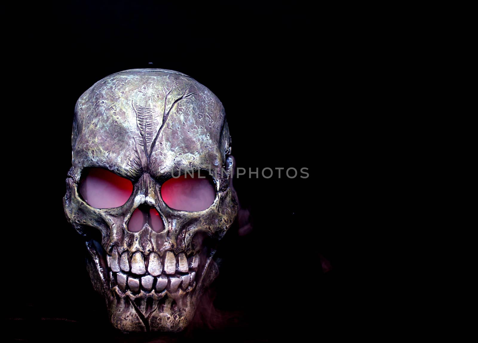 A Halloween prop skull with fog coming from it's eyes and nose.