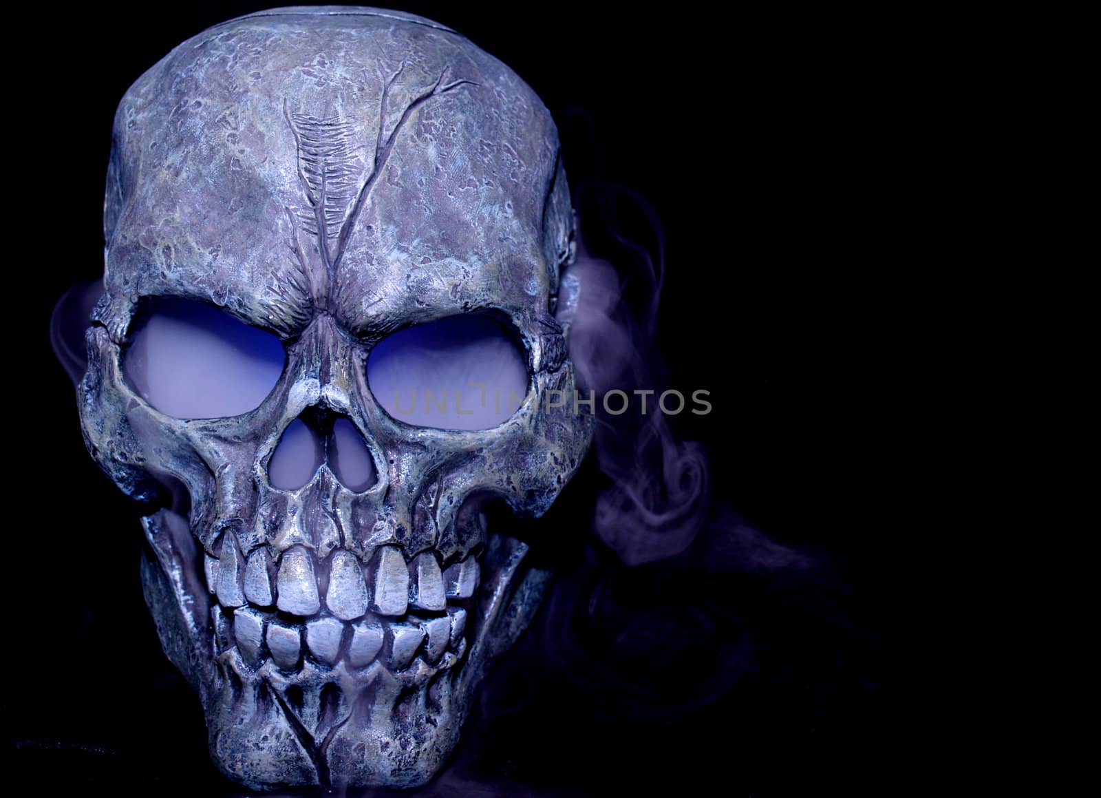 A Halloween prop skull with fog coming from it's eyes and nose.