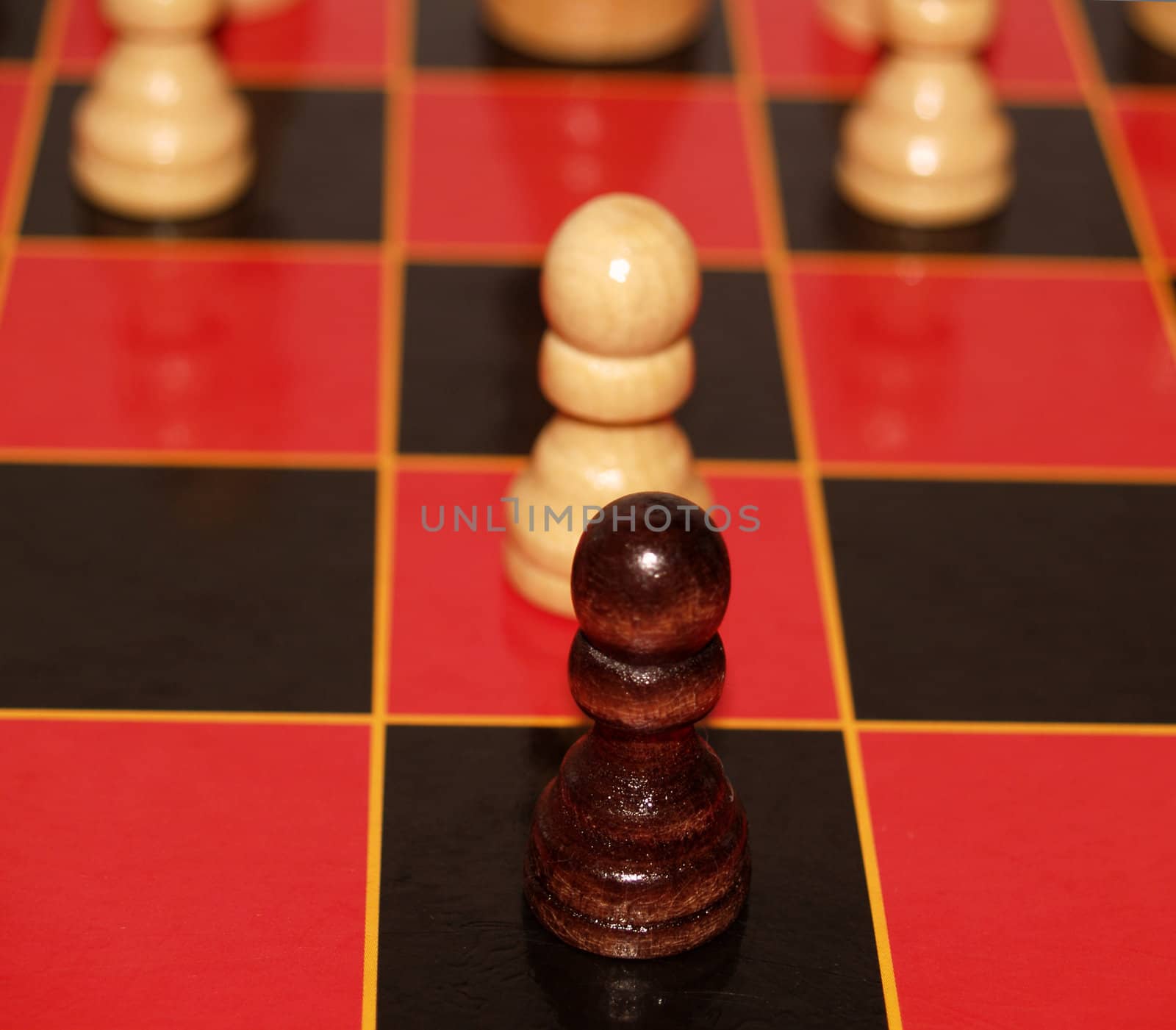 Two pawns face off on a red and black chess board