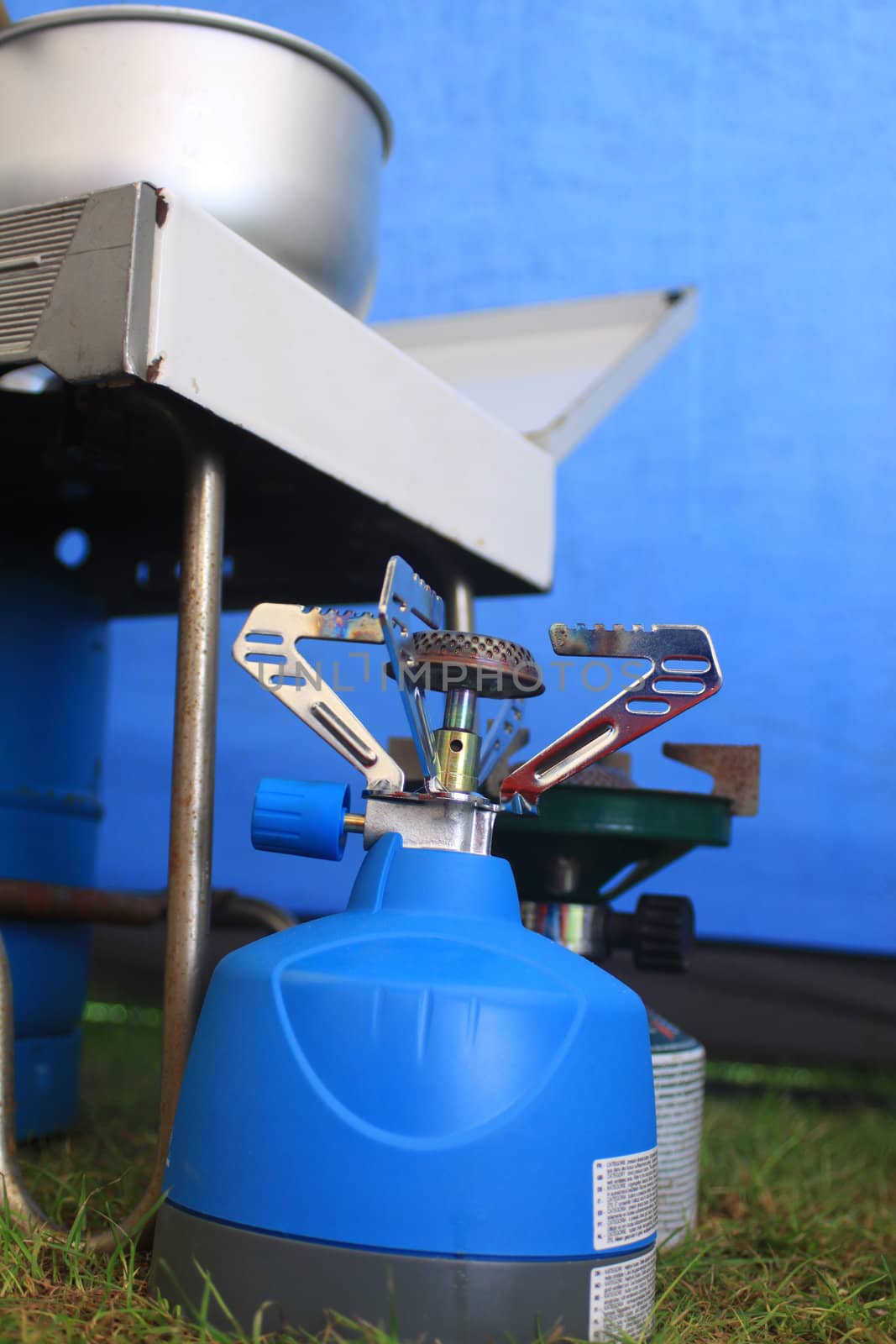 Mini camping gas stoves set inside a blue canvas tent.