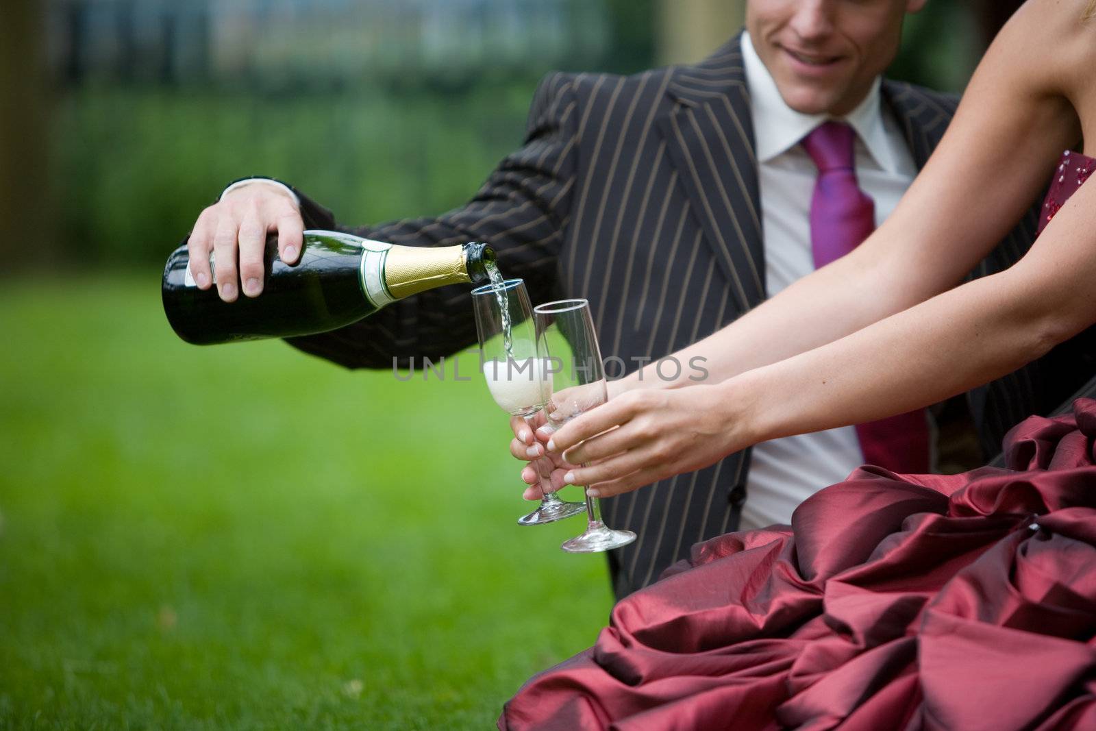 Male pouring champagne into the glass of his new bride