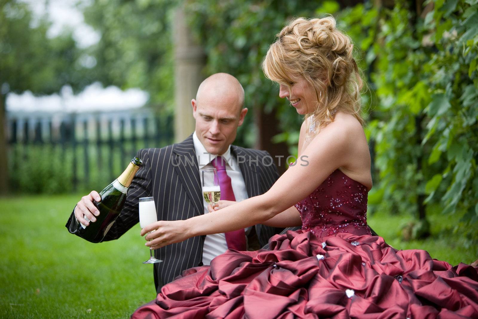 Groom pouring his new wife a glass of champagne (focus on bride, shallow dof)