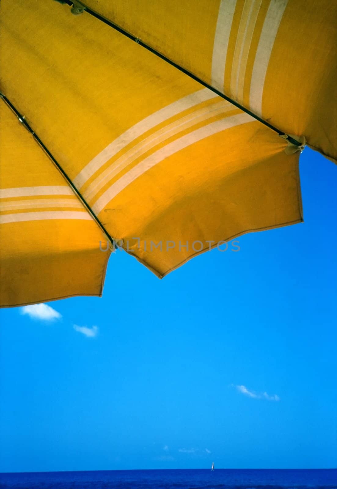 Yellow  umbrella against clear blu summer sky