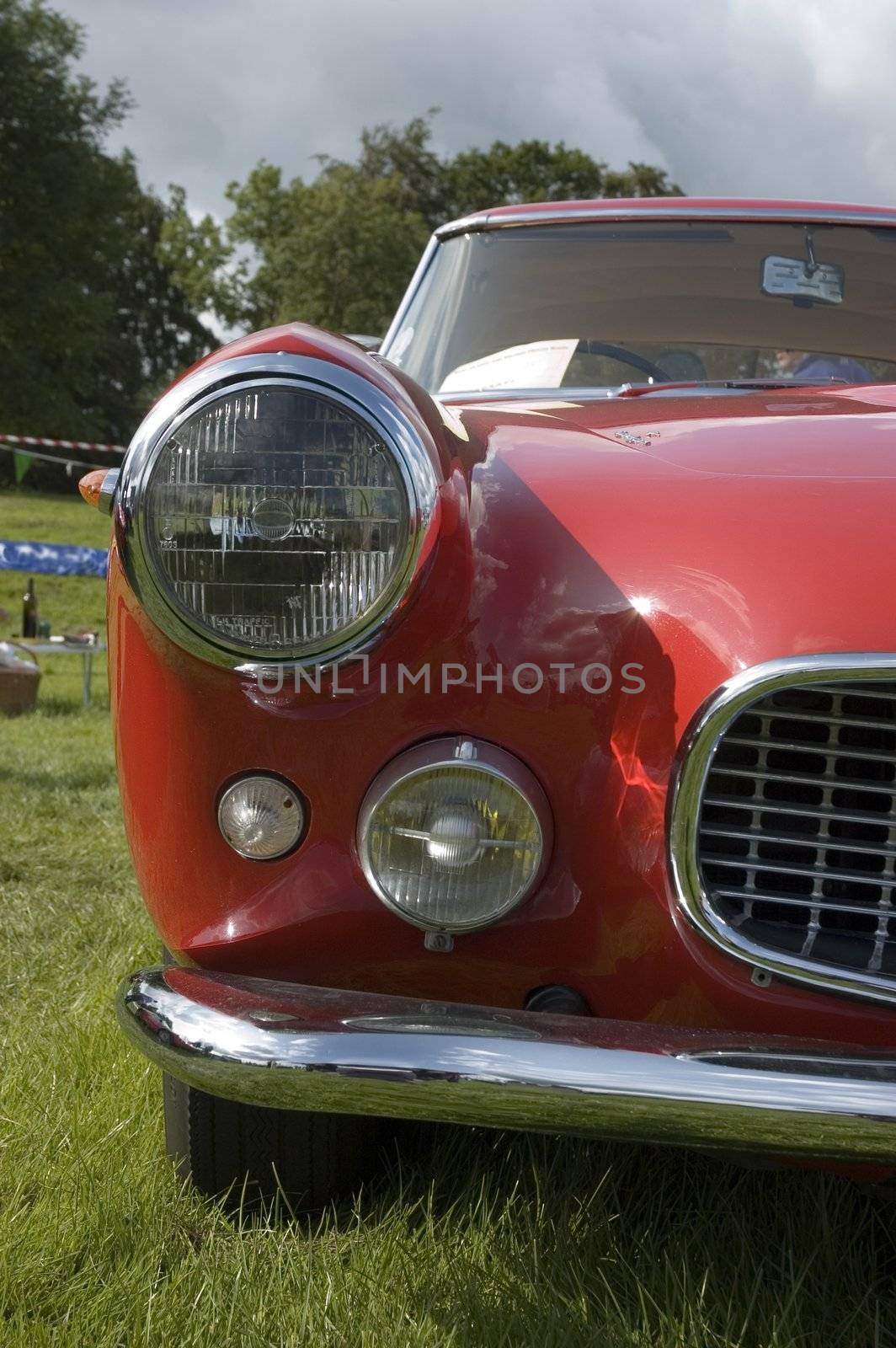 !960's Bright Red Maserati Sports Classic Car at a local show in summertime