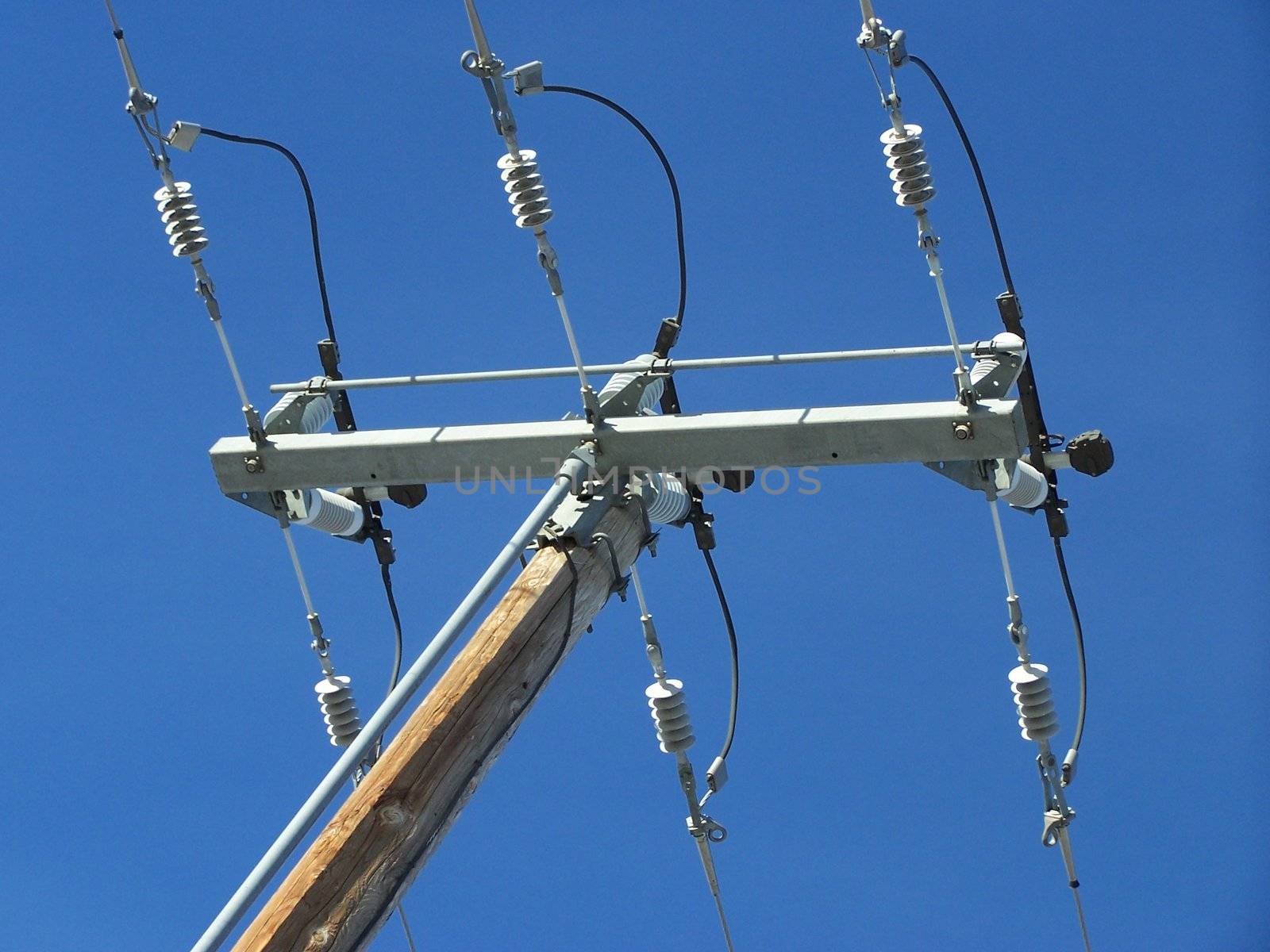 hydro pole and lines cut through the view of blue sky