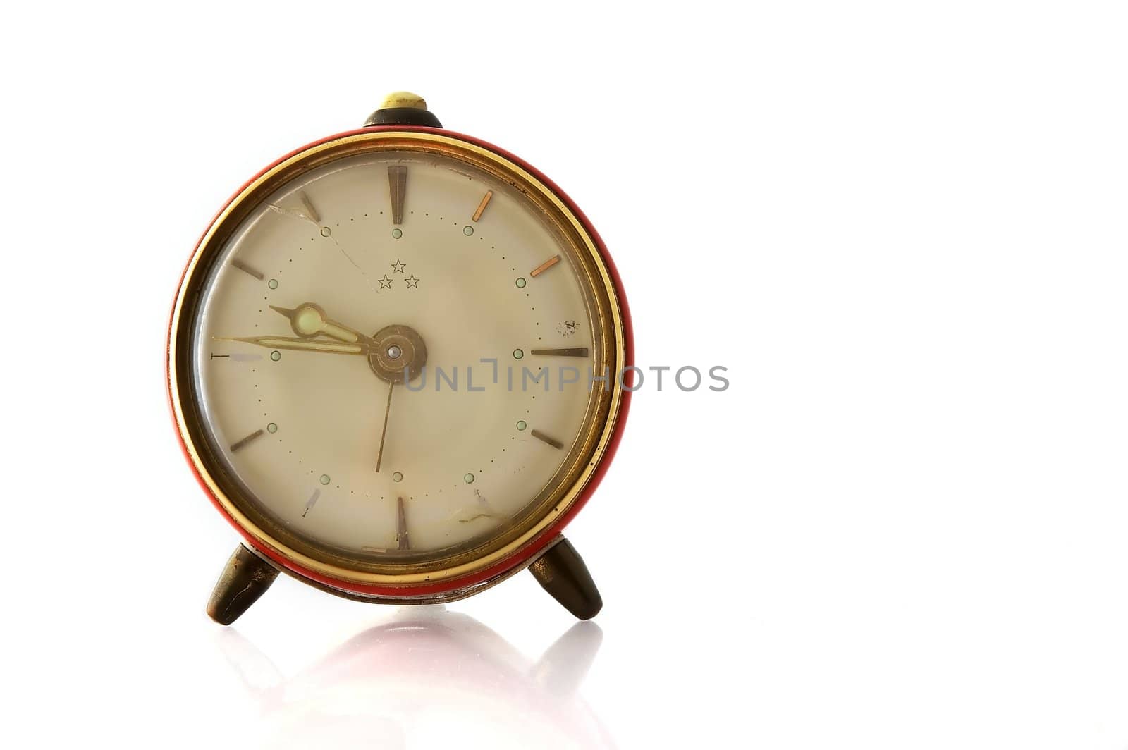 Old and cracked alarm clock isolated on white