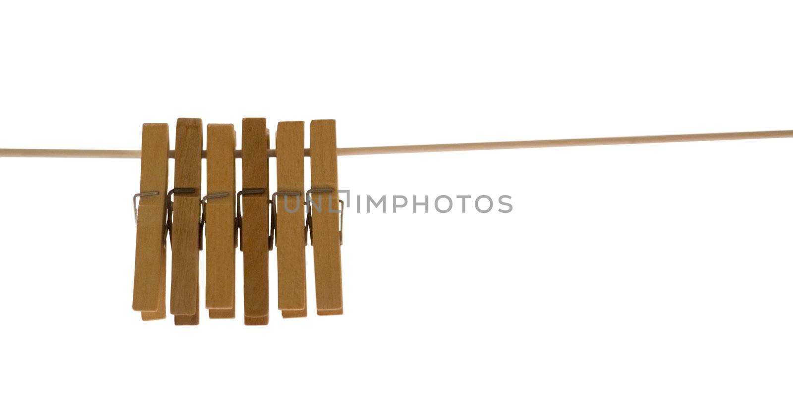 Wooden pegs hanging from a rope against white background