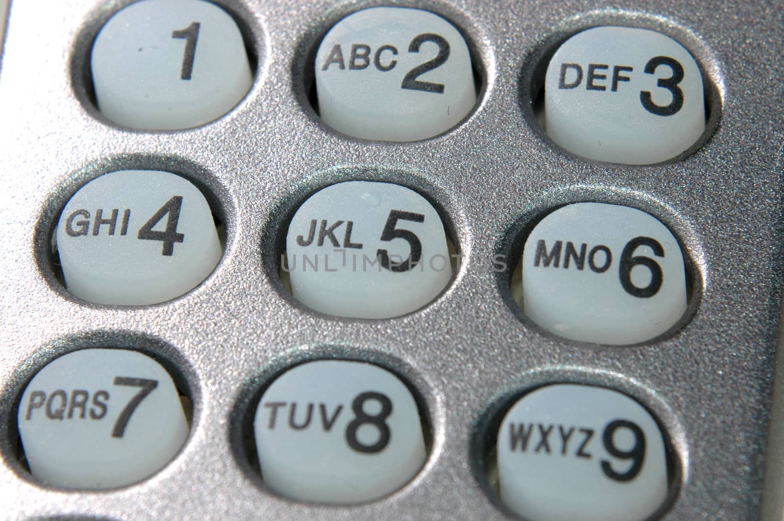 Close up of silver wireless telephone with white keys
