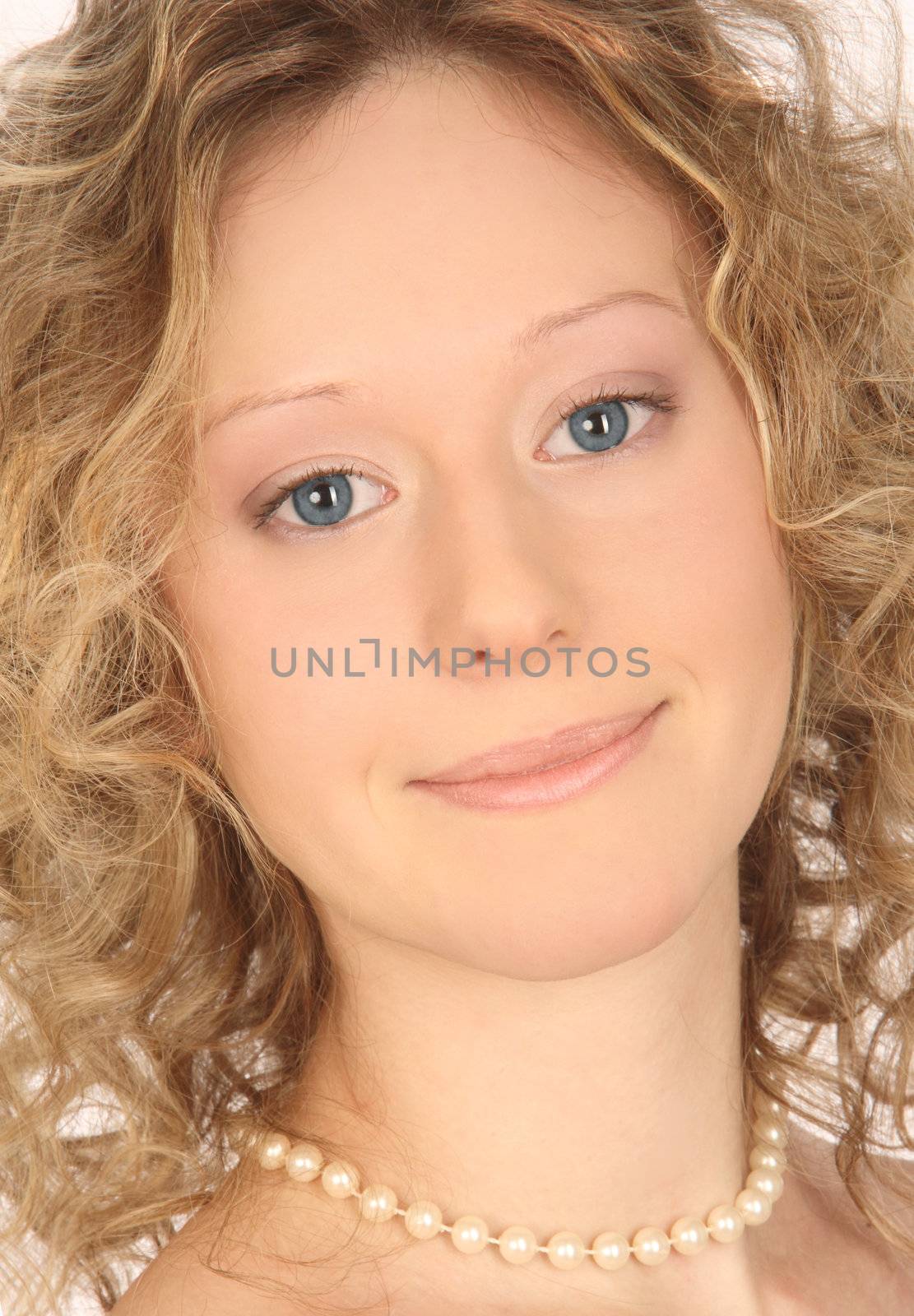 Portrait lovely young smiling girl with blue eyes and light ringlets in a pearl necklace close up
