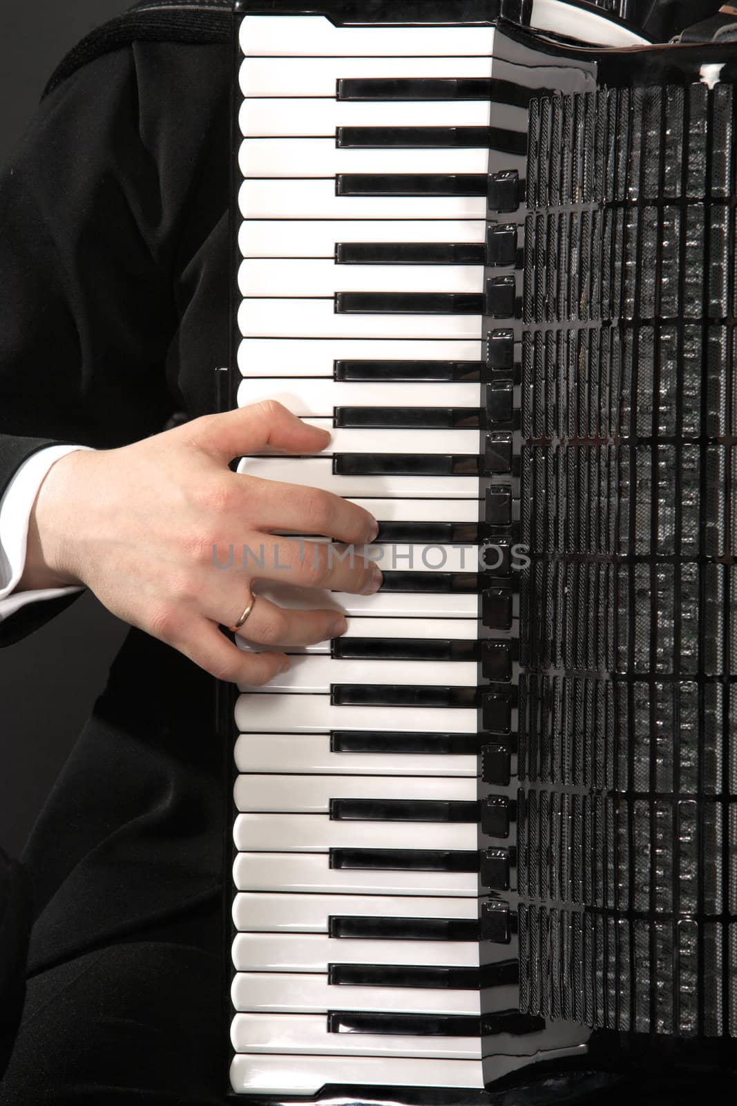 The keyboard of an accordion with a hand of the musician
