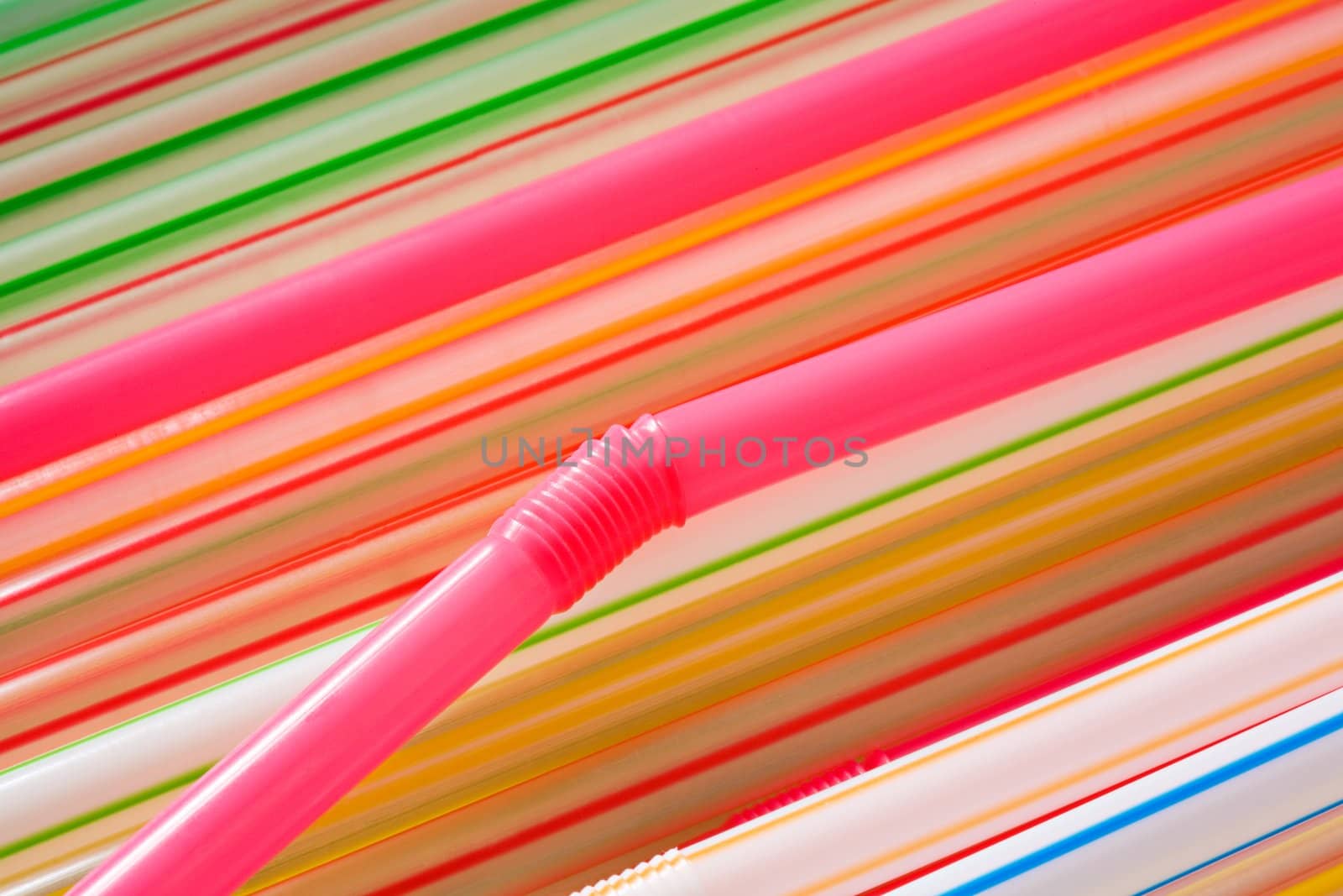 Multi-coloured straws for a cocktail close up
