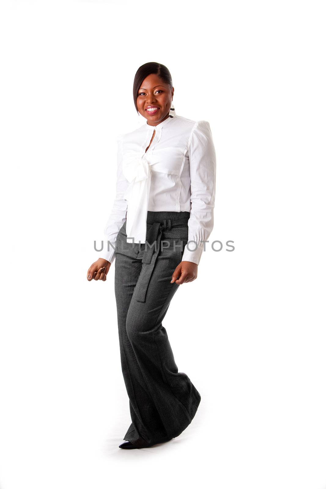 Beautiful African American business woman with attitude dressed in a white shirt and gray pants standing, dancing happy, isolated