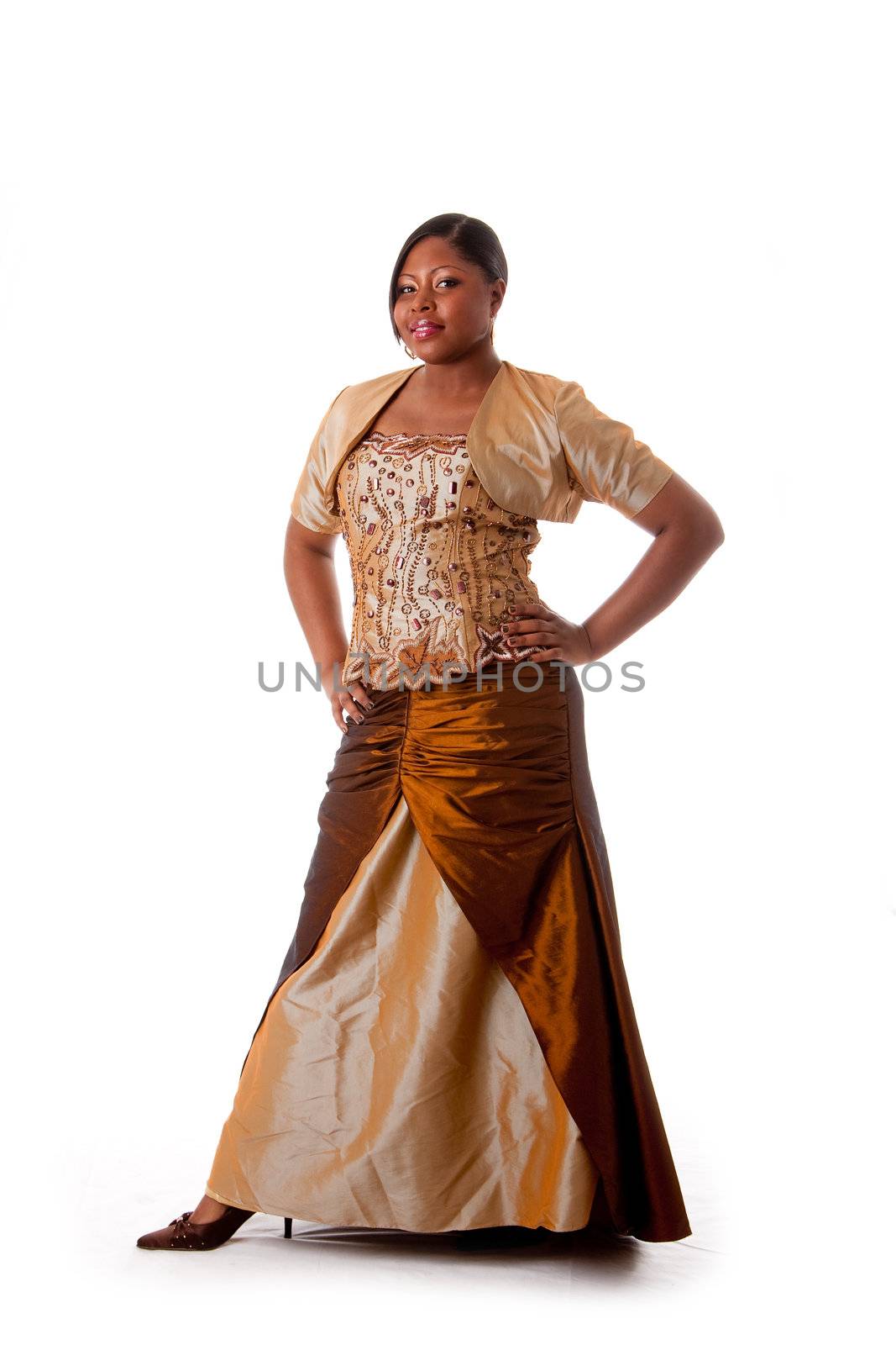 Beautiful African American woman in brown with gold dress, hands on hips and standing, isolated