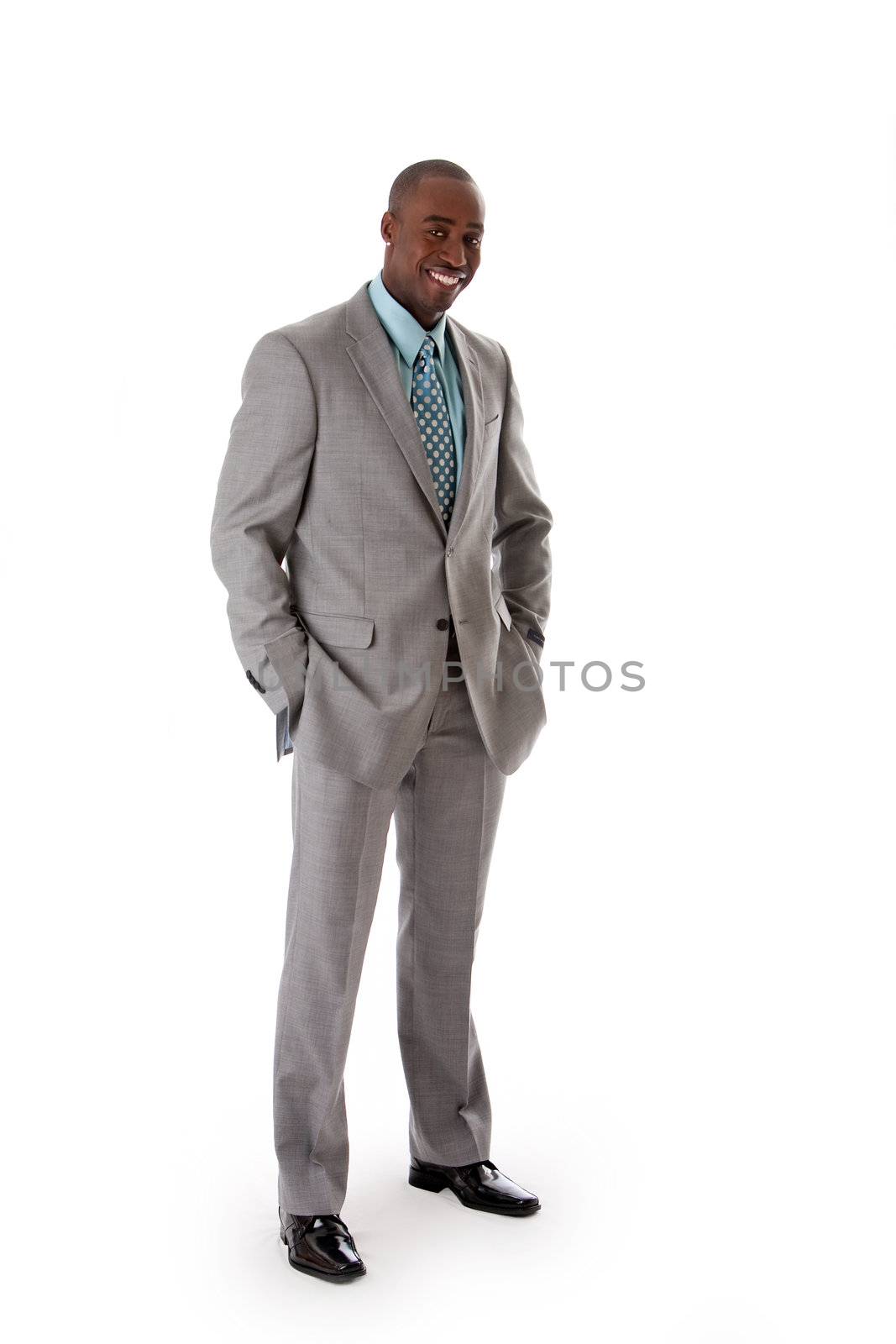 Handsome African American man in gray suit with smile standing with hands in pocket, isolated