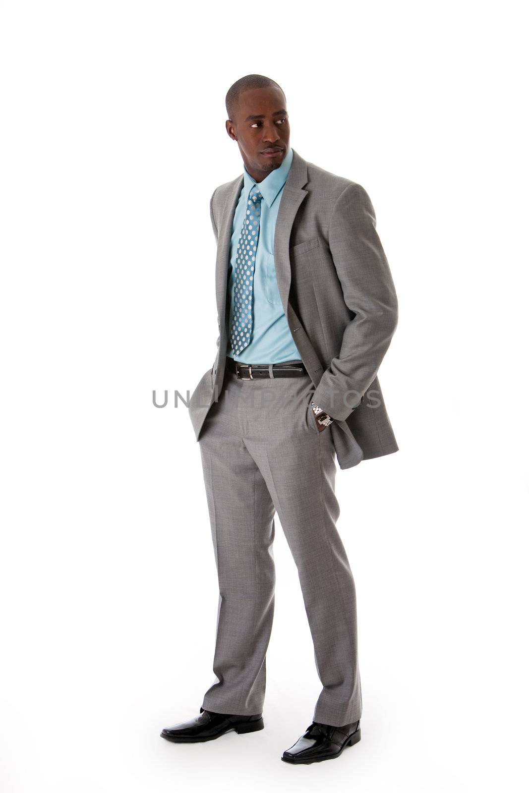 Handsome African American man in gray suit with smile standing with hands in pocket, isolated