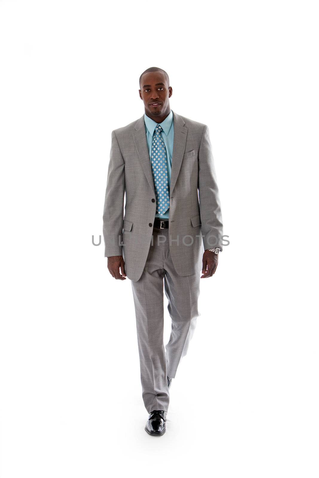 Handsome African American man in gray suit with smile walking, isolated