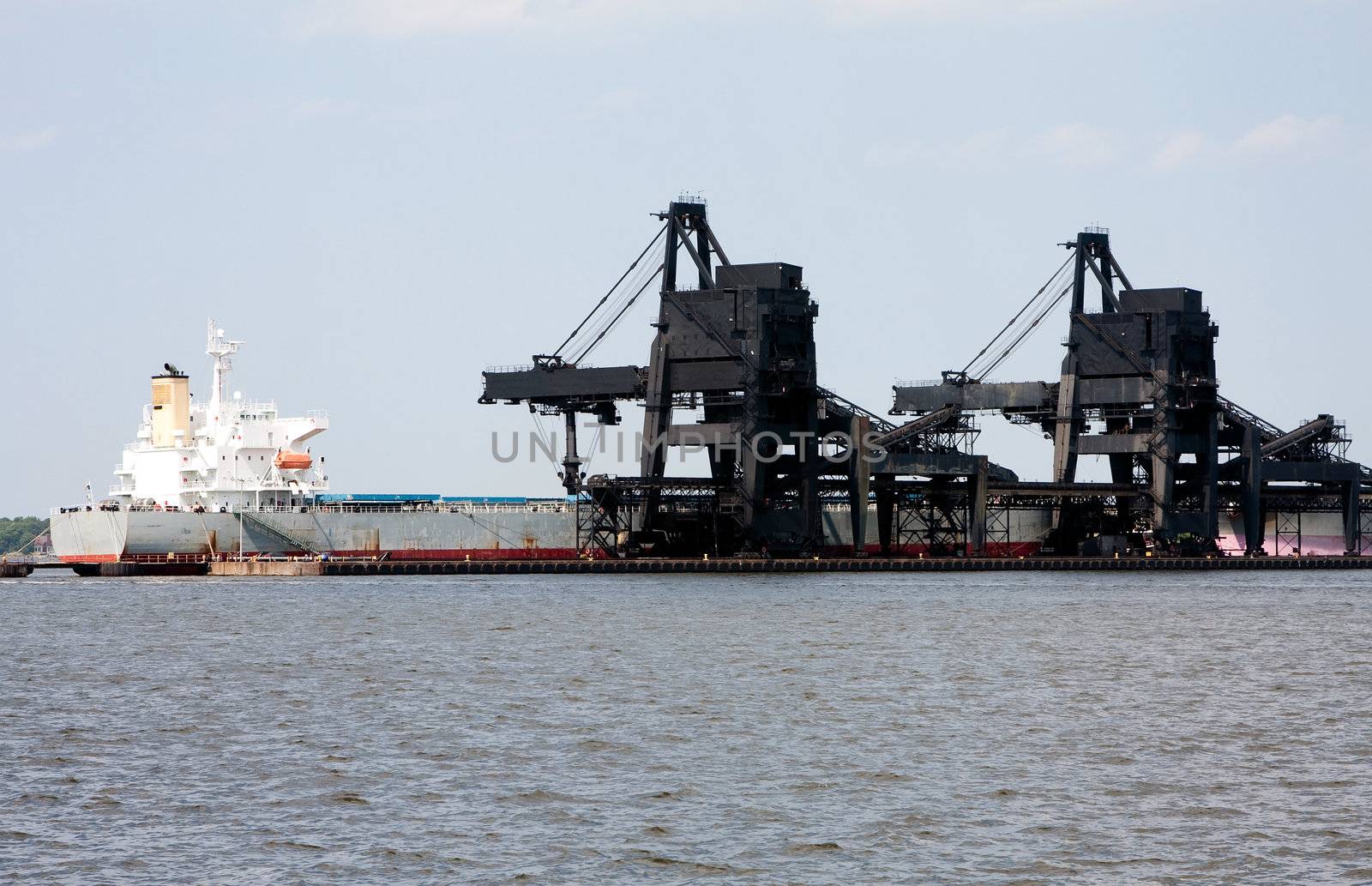 The black Coal Pier Six (6) in Norfolk, Virginia, loading charcoal on a white transport ship