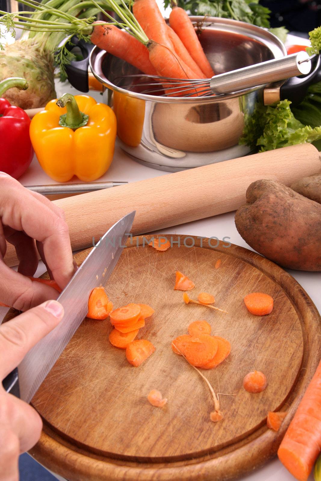 chef cutting carrots on a cutting board