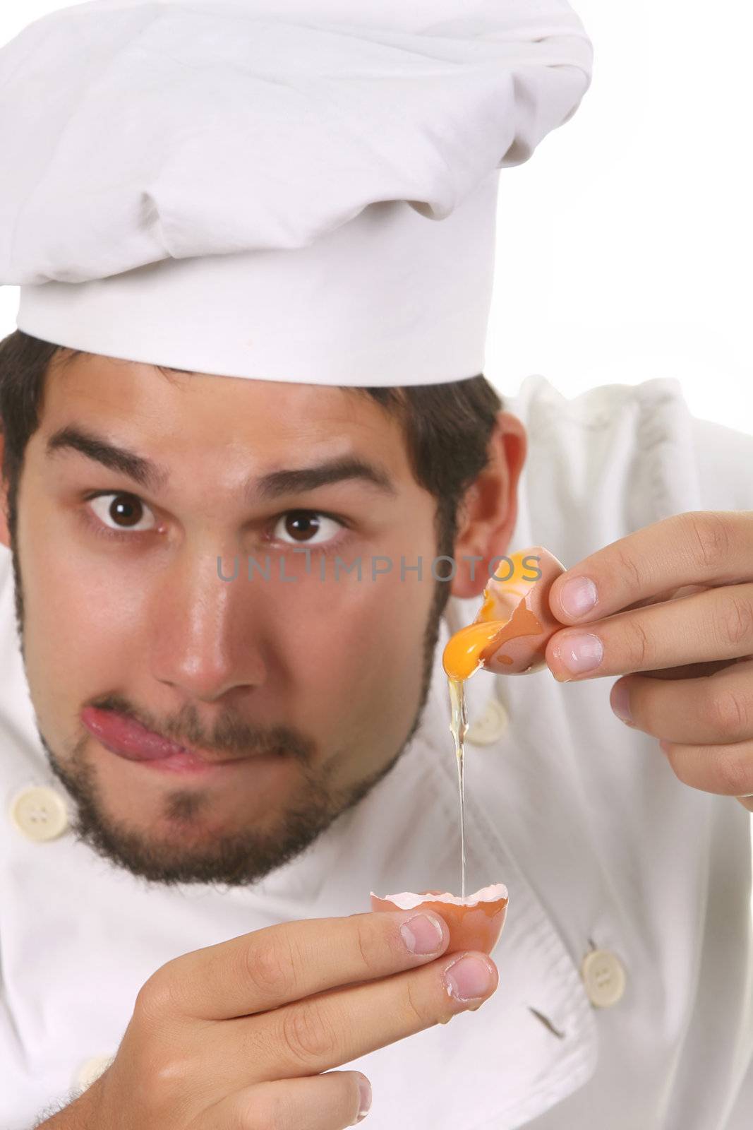 young funny chef cracking an egg, focus on egg