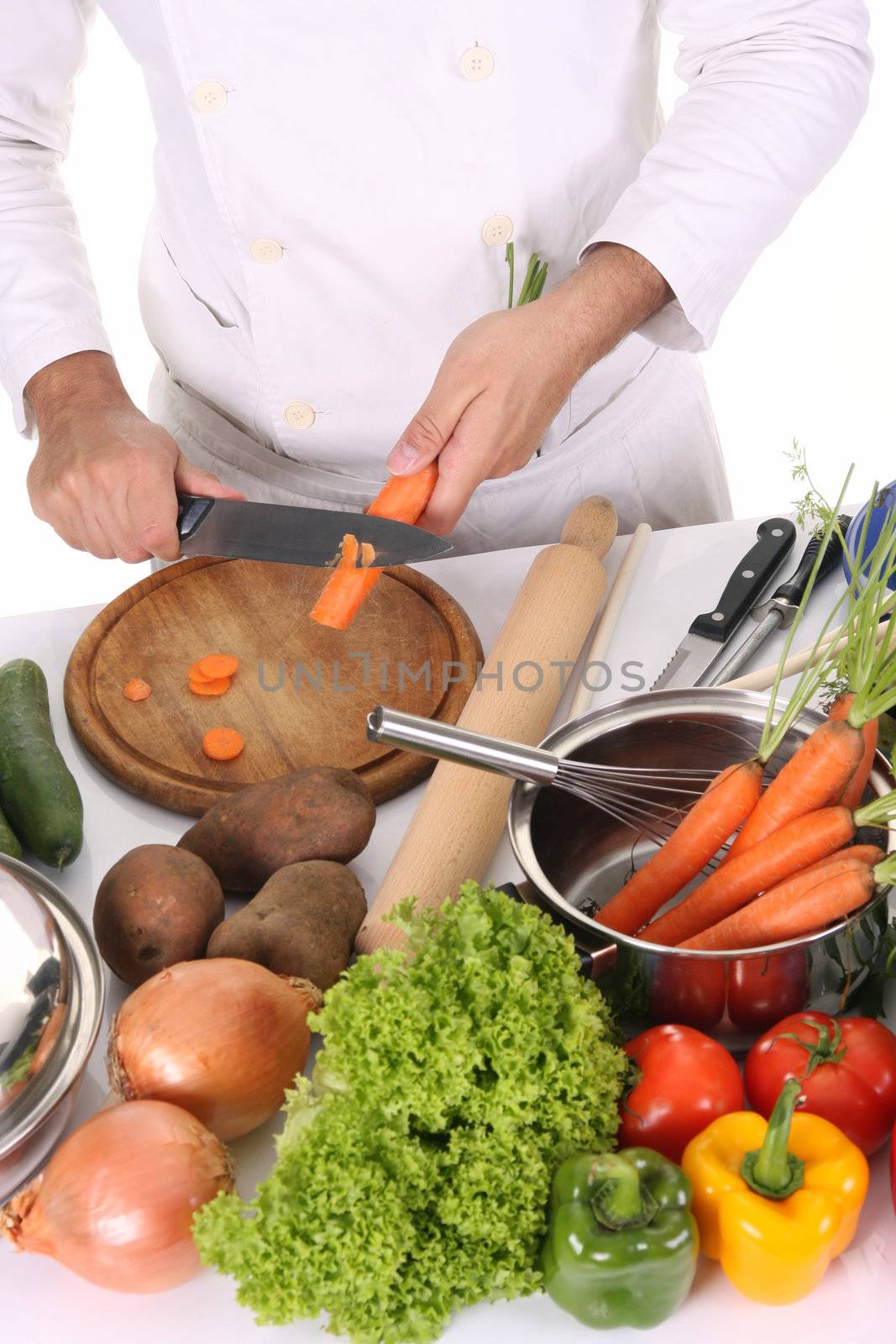 chef preparing lunch and cutting carrot with knife