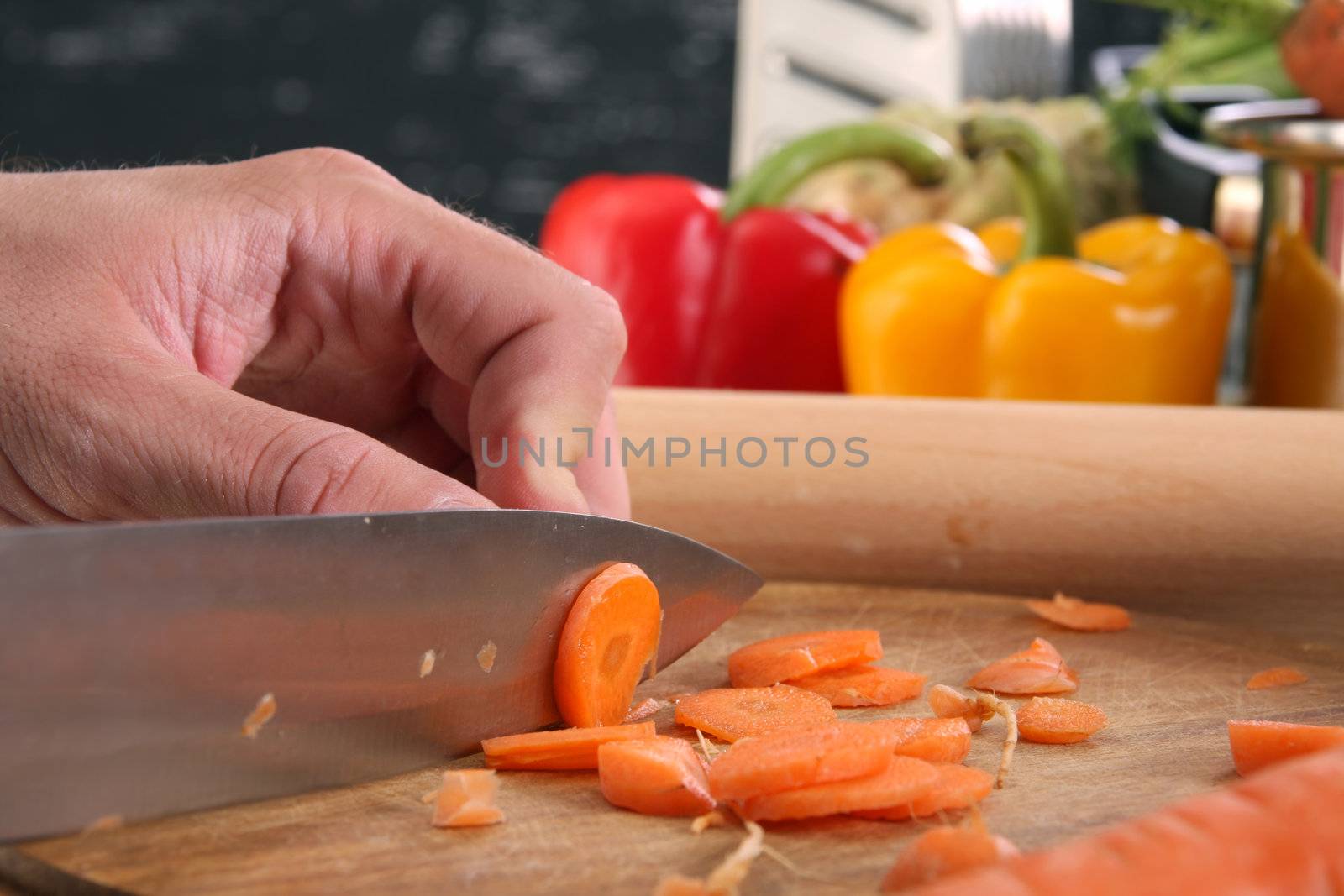 chef preparing lunch and cutting carrot with knife