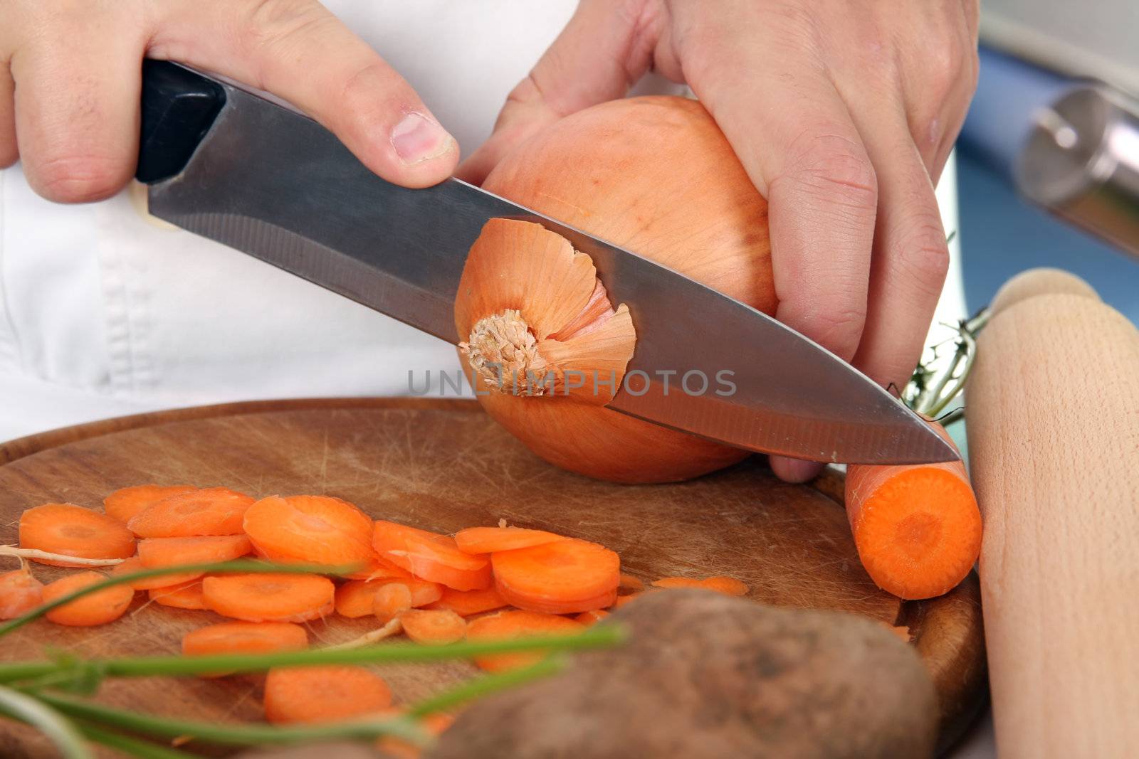 chef preparing lunch and cutting onion with knife