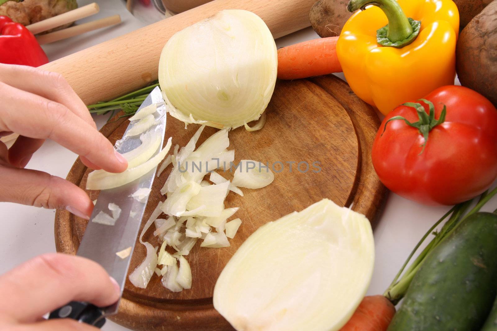 chef preparing lunch and cutting onion with knife