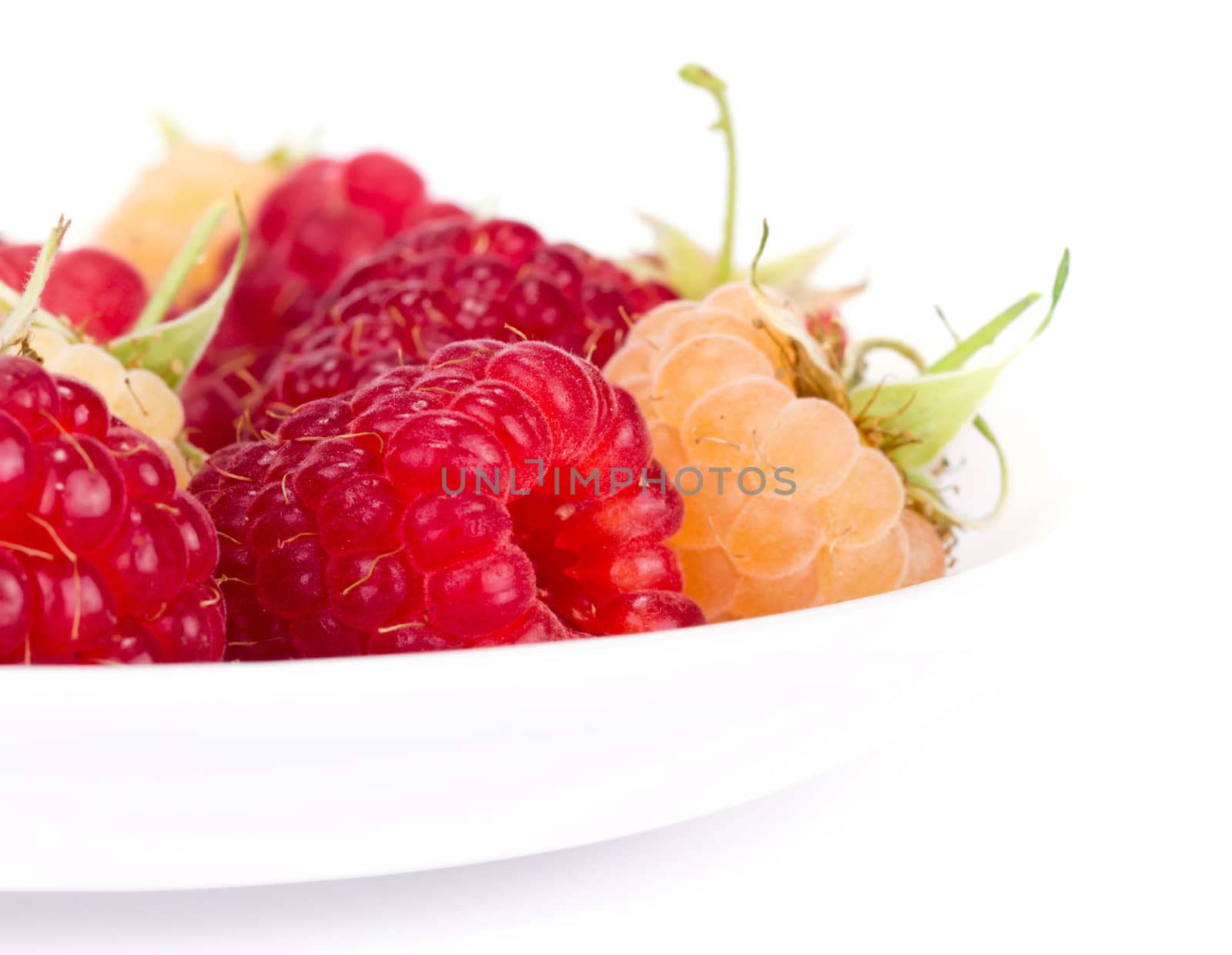 plateful of fresh raspberries on white