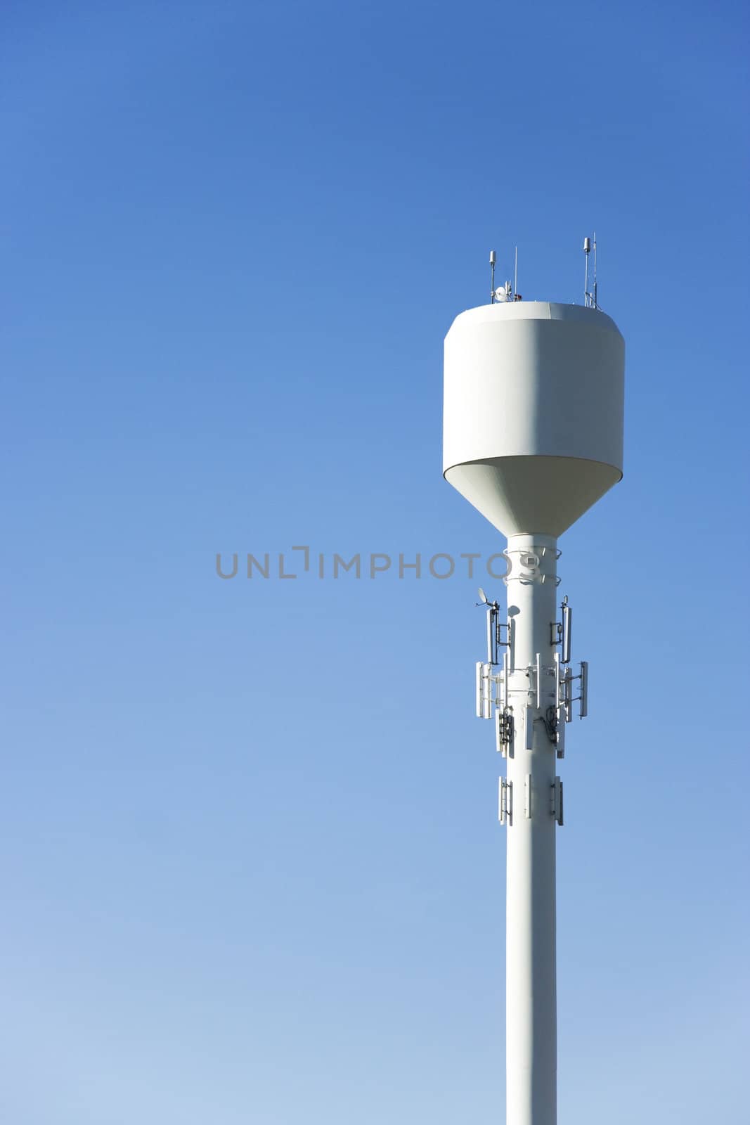 A white water tower with plenty of sky for copyspace