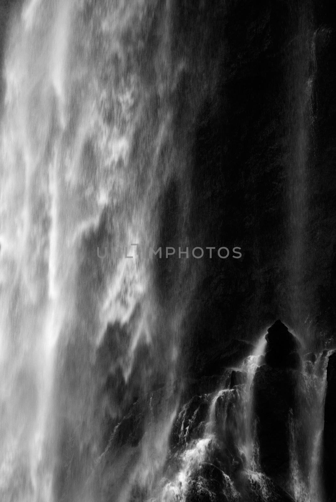 It is dramatic blurred view of waterfall flowing over rocks.