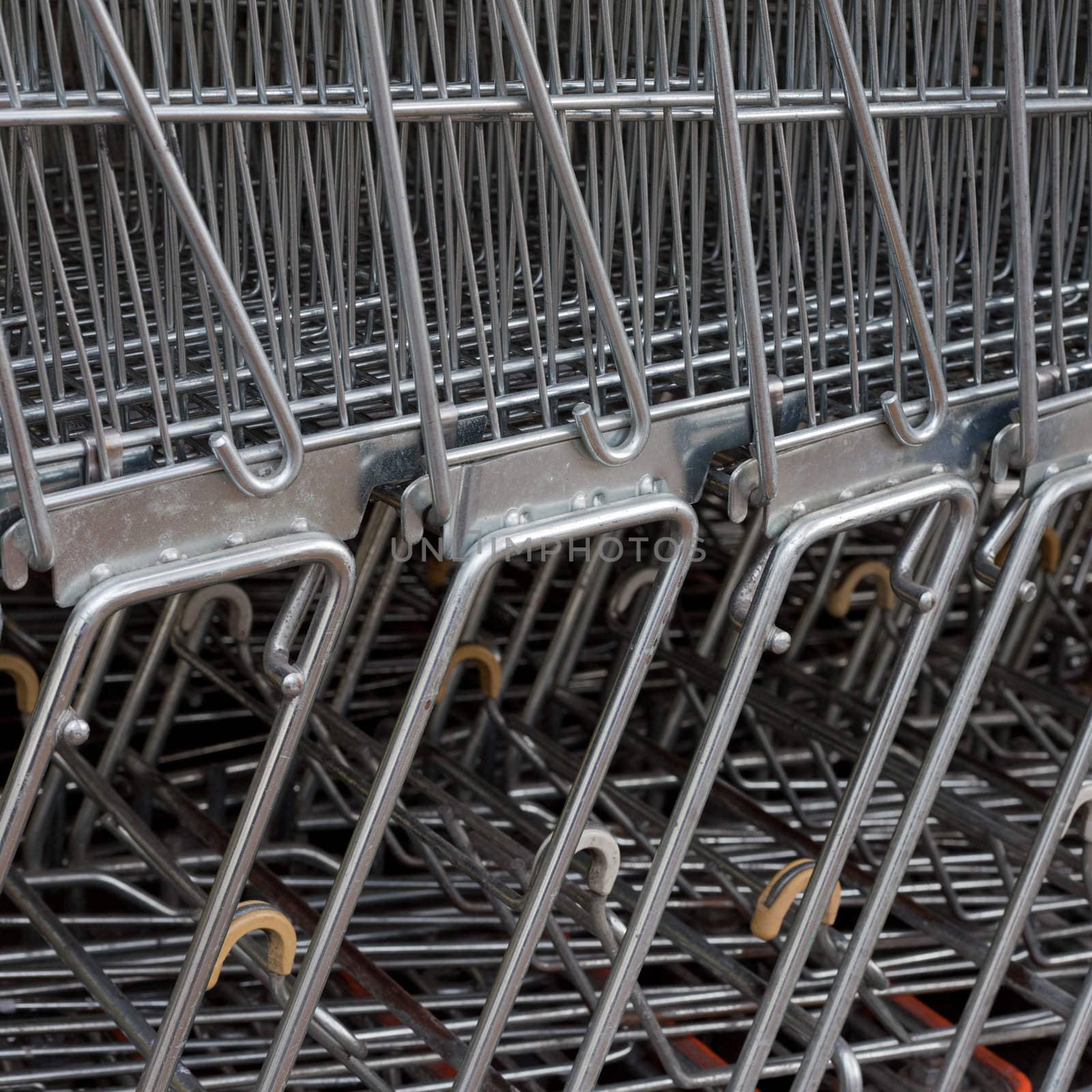 Detail of shiny metal shopping carts stacked in a row.