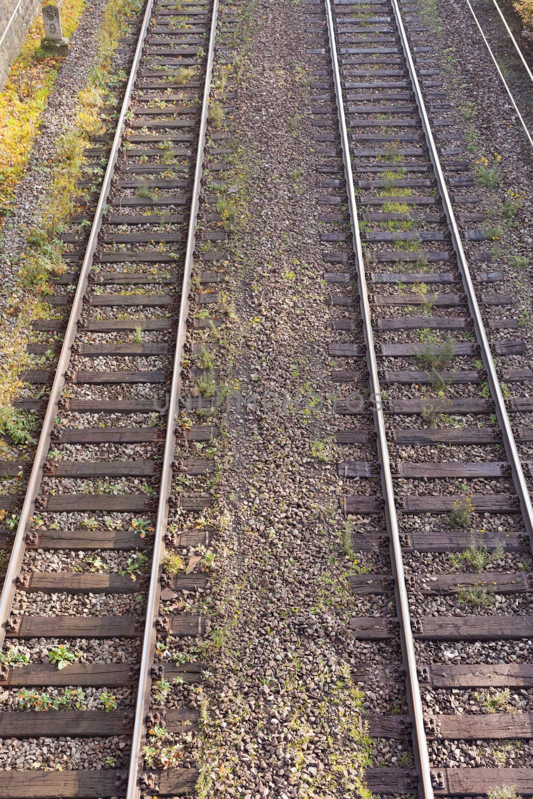 Two parallel railway tracks in embankment of gravel.