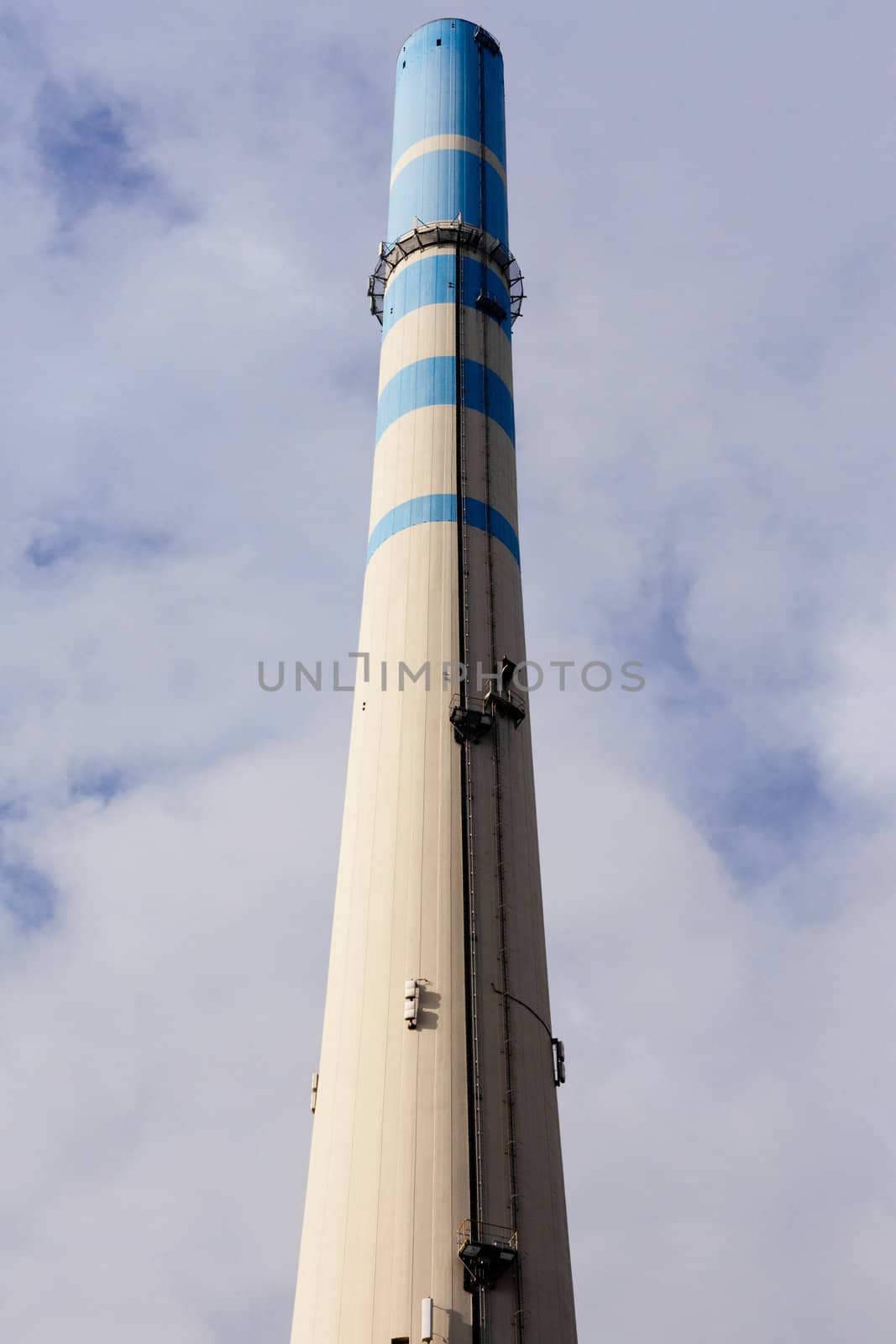 White-blue industrial high concrete chimney.