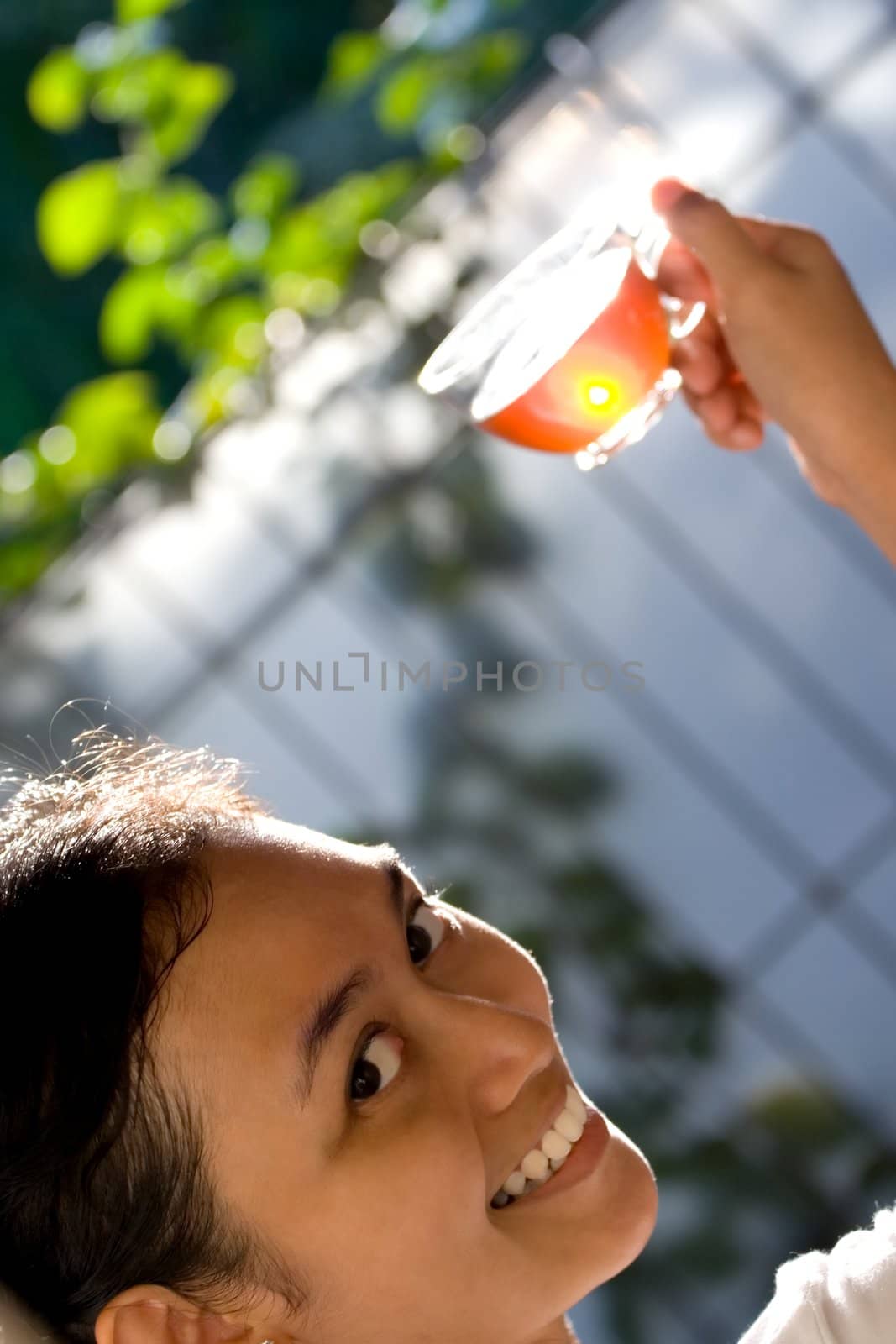a beautiful asian young woman smiling and offering a cup of hot tea