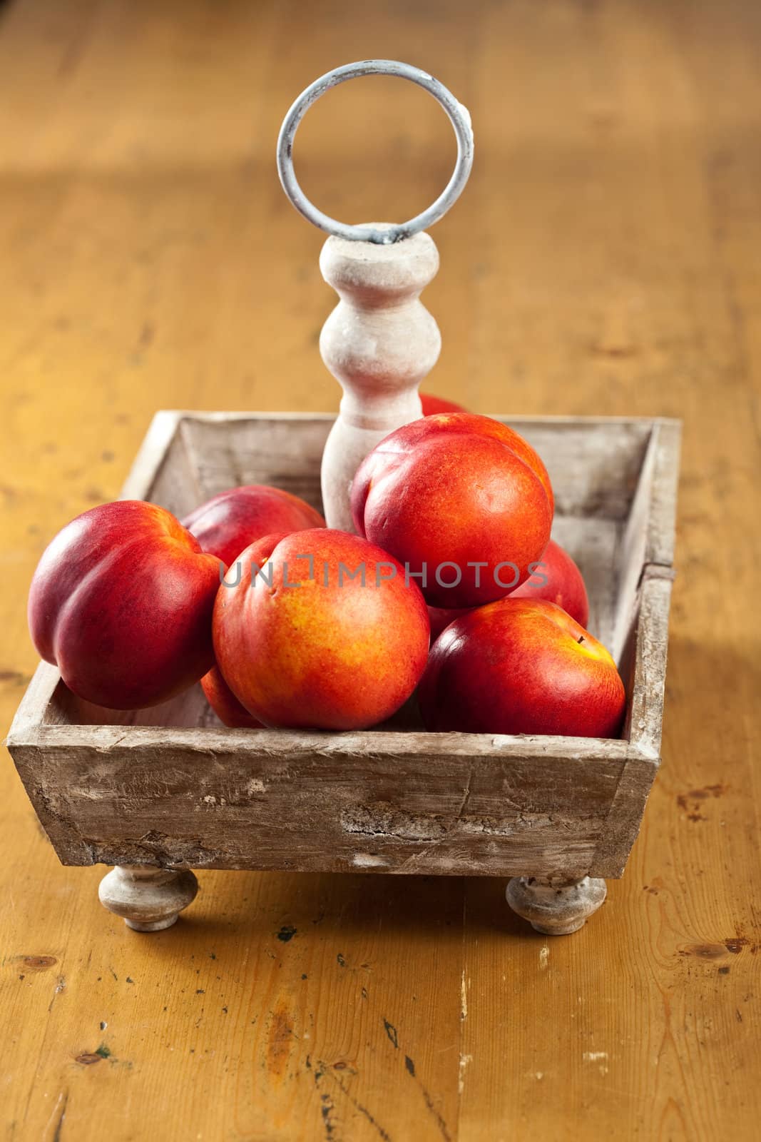 Ripe nectarines waiting to be eaten in a wooden basket