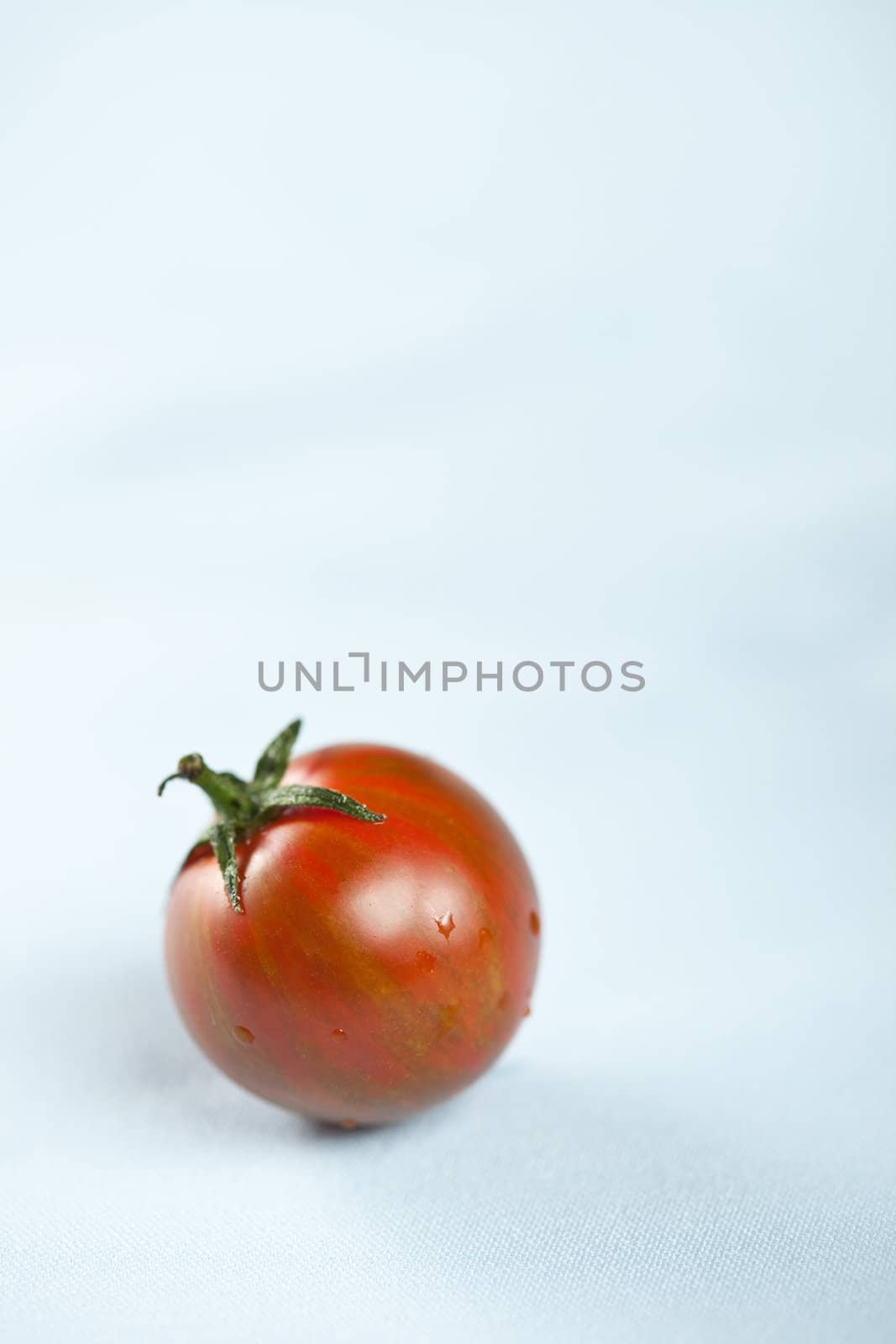 Small ripe tiger tomatoe on table surface