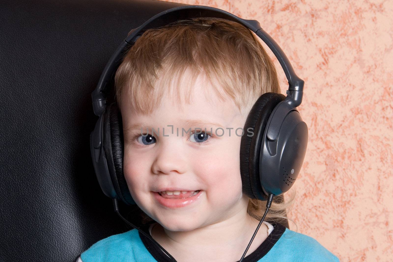 child in earphone listens music 