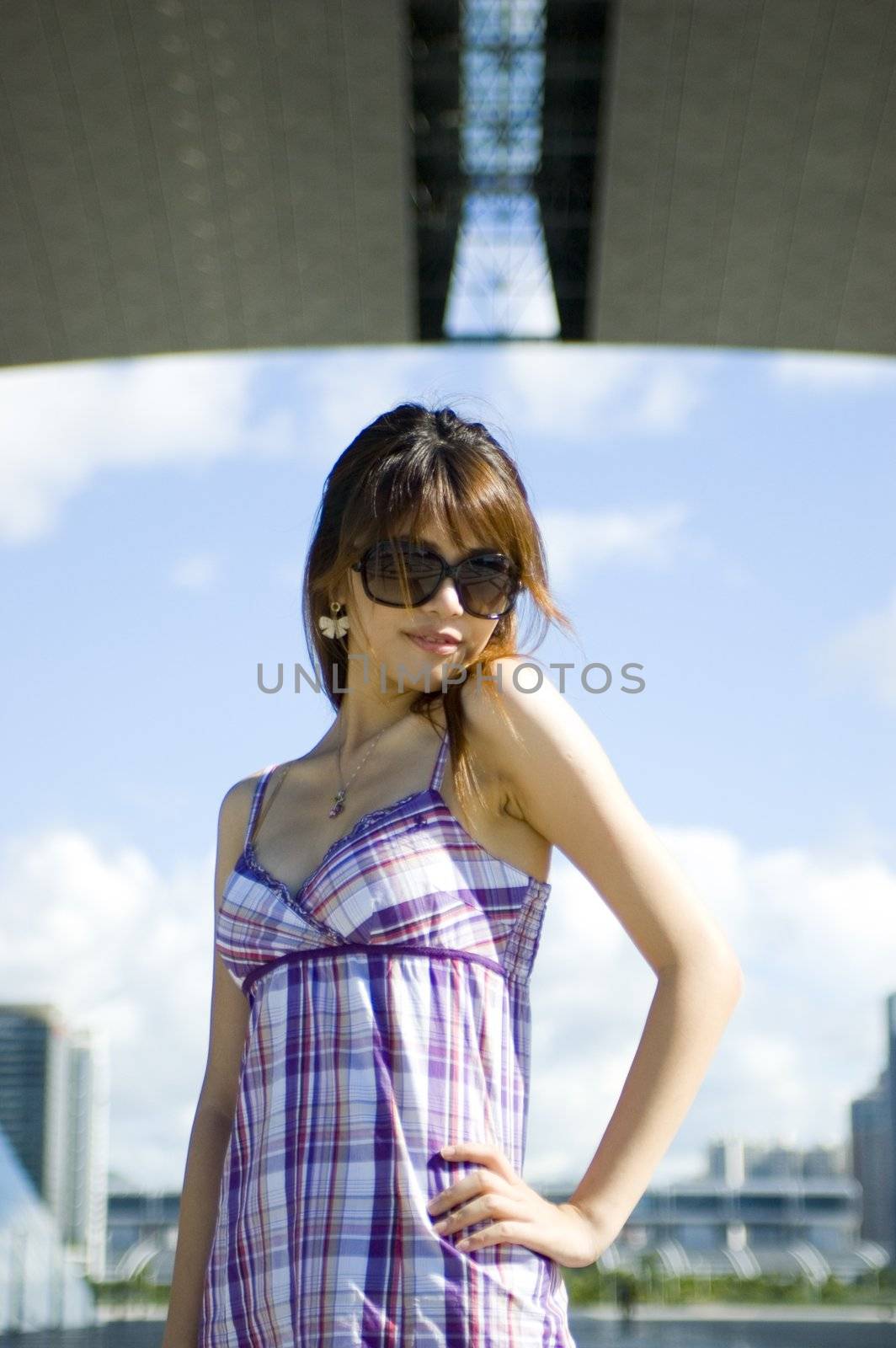 Fashionable Chinese girl in the city. Young female model, pretty Asian girl, fashionable and confident with modern skyscrapers as background.