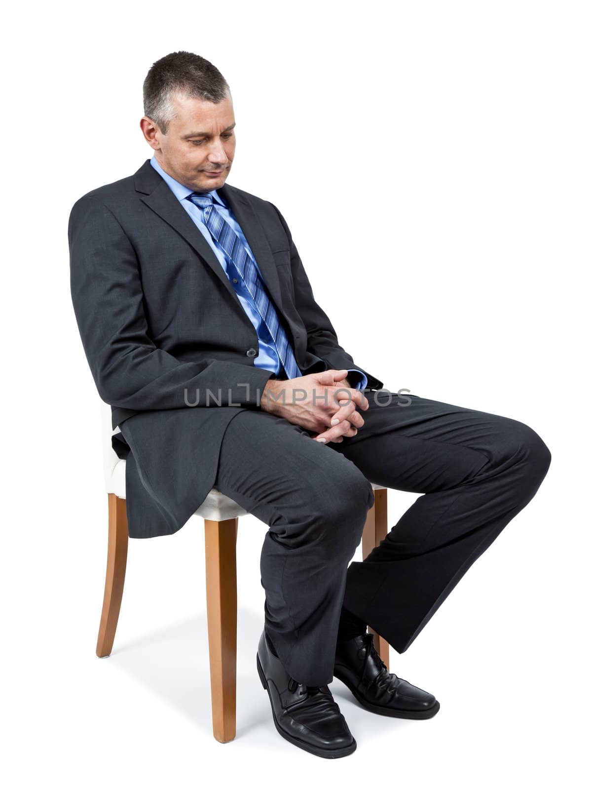 A sitting handsome business man is looking down