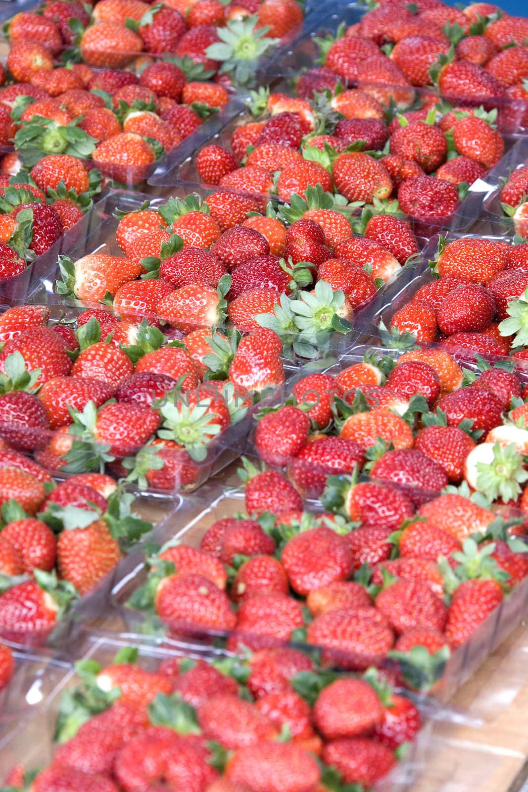 Image of freshly harvested strawberries for sale at a farmers' market.