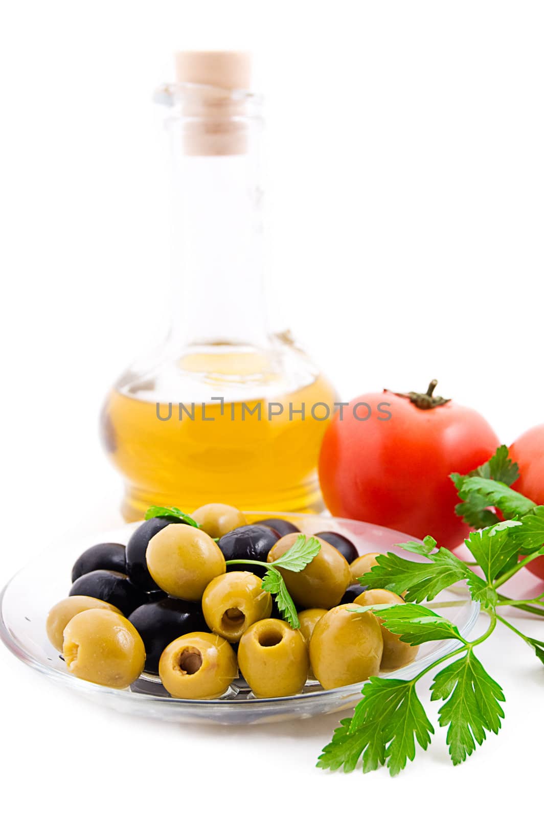 Olive oil, tomatoes and greens isolated on white