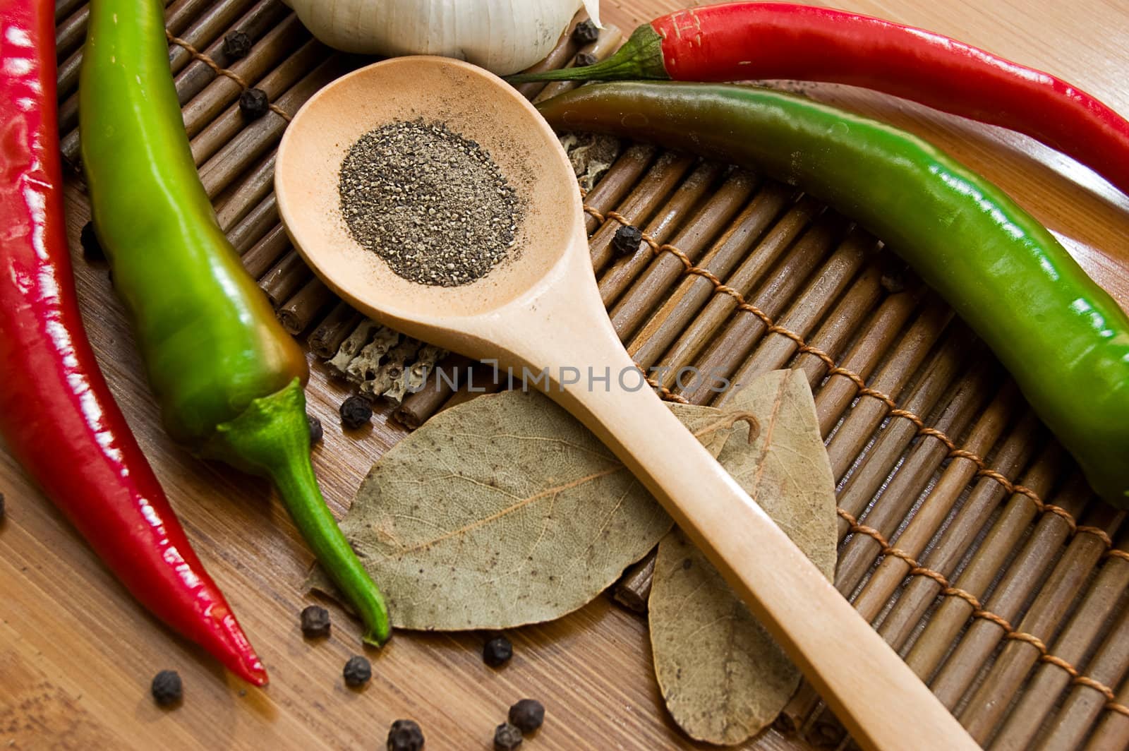 Some kinds of pepper and bay leaf on wooden plate