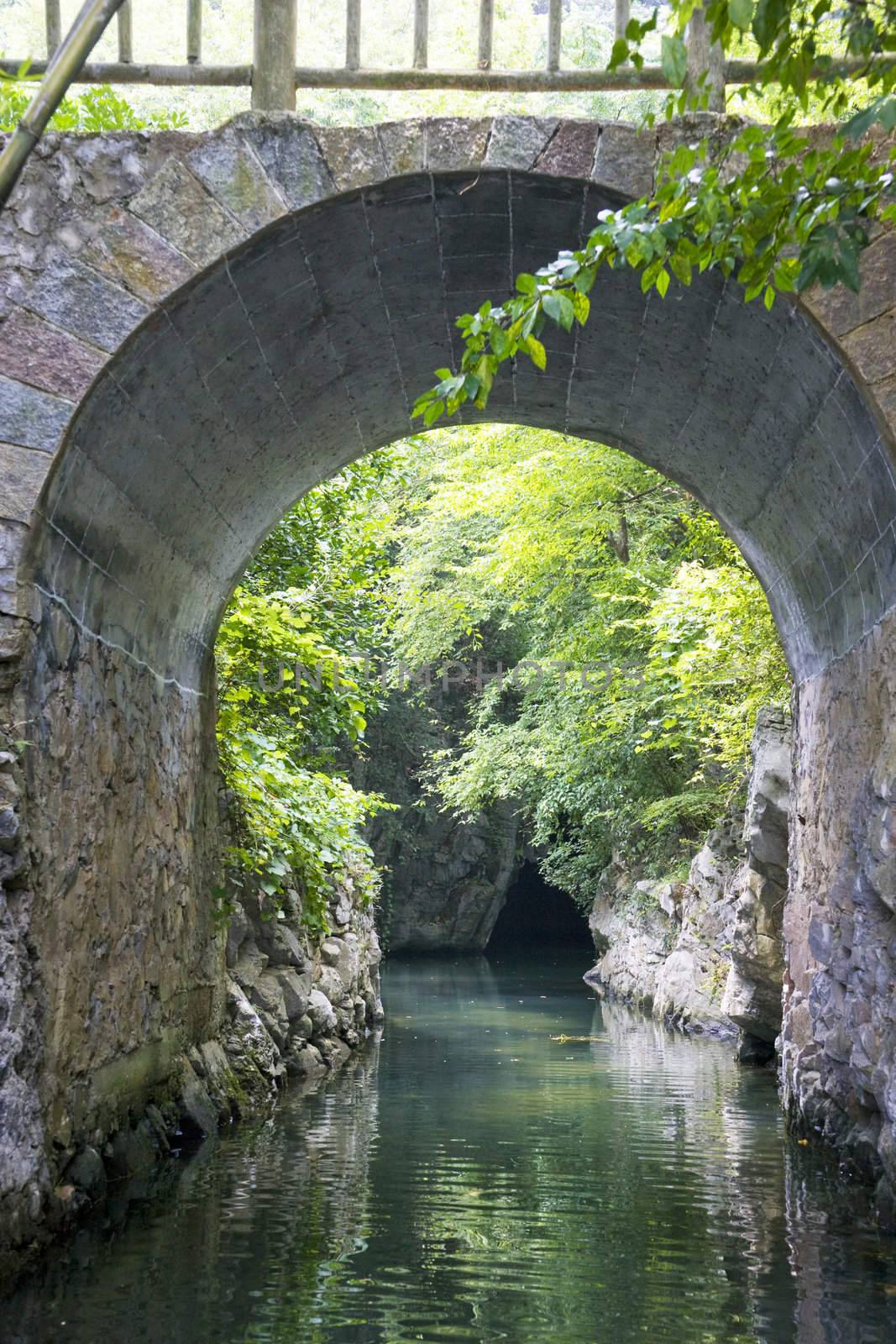 Image of an entrance to a cave through a bridge at Guilin, China.