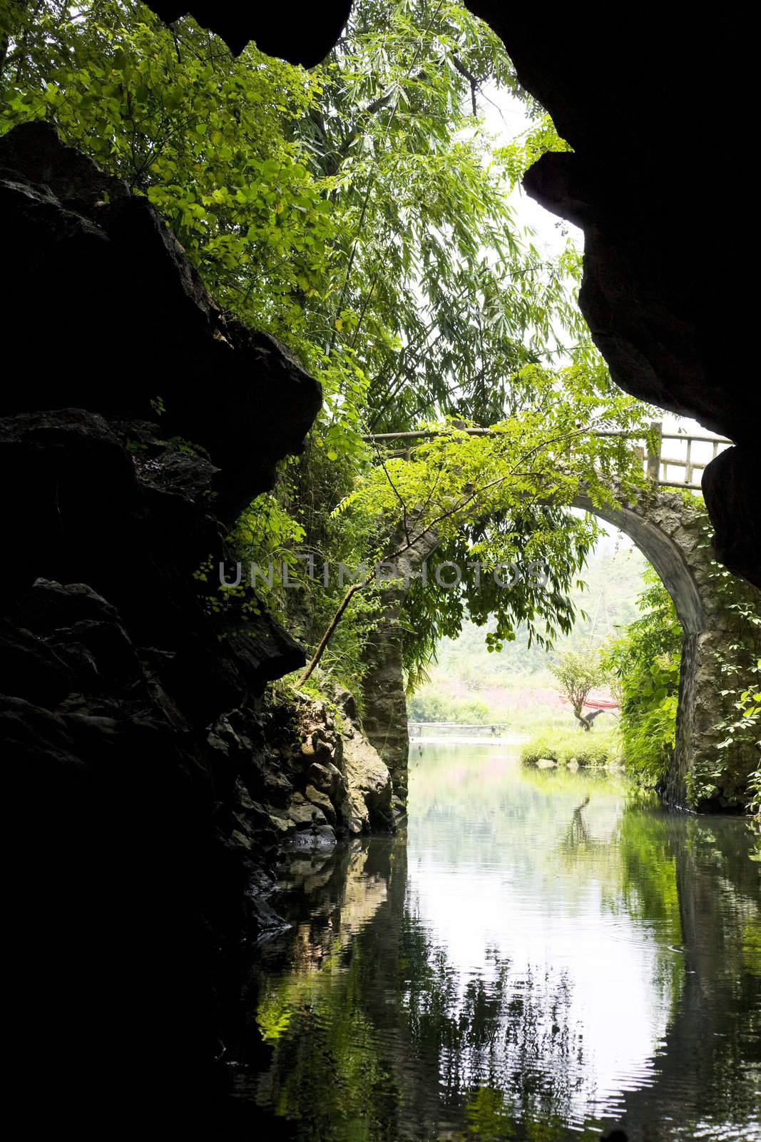 Image of a cave exit and a country bridge at Guilin, China.