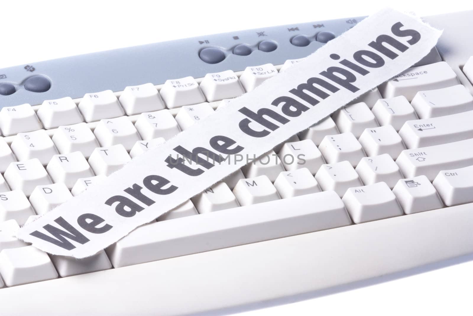 Image of a newspaper cutting with the words "We are the Champions" placed on a computer keyboard.