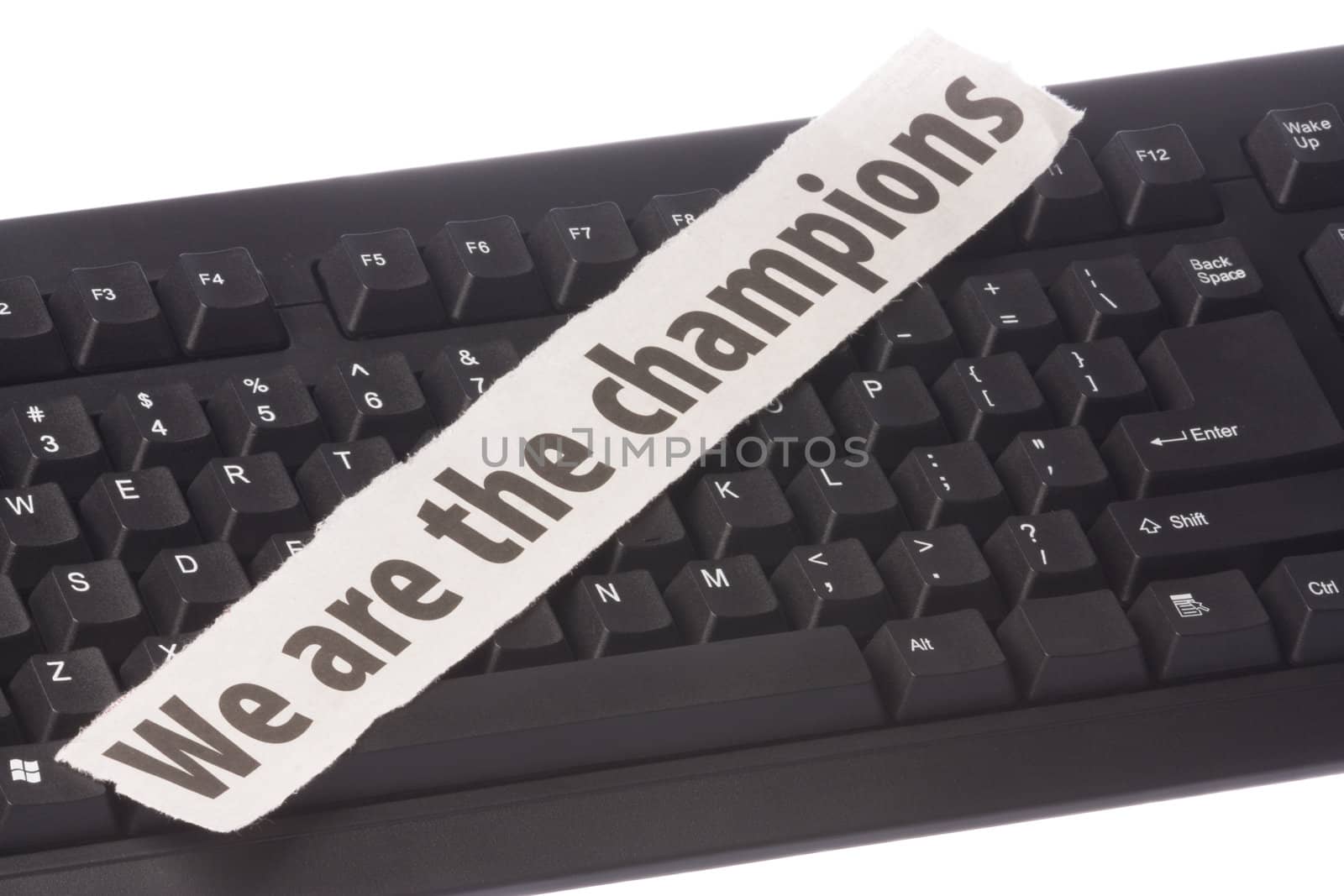Image of a newspaper cutting with the words "We are the Champions" placed on a computer keyboard.