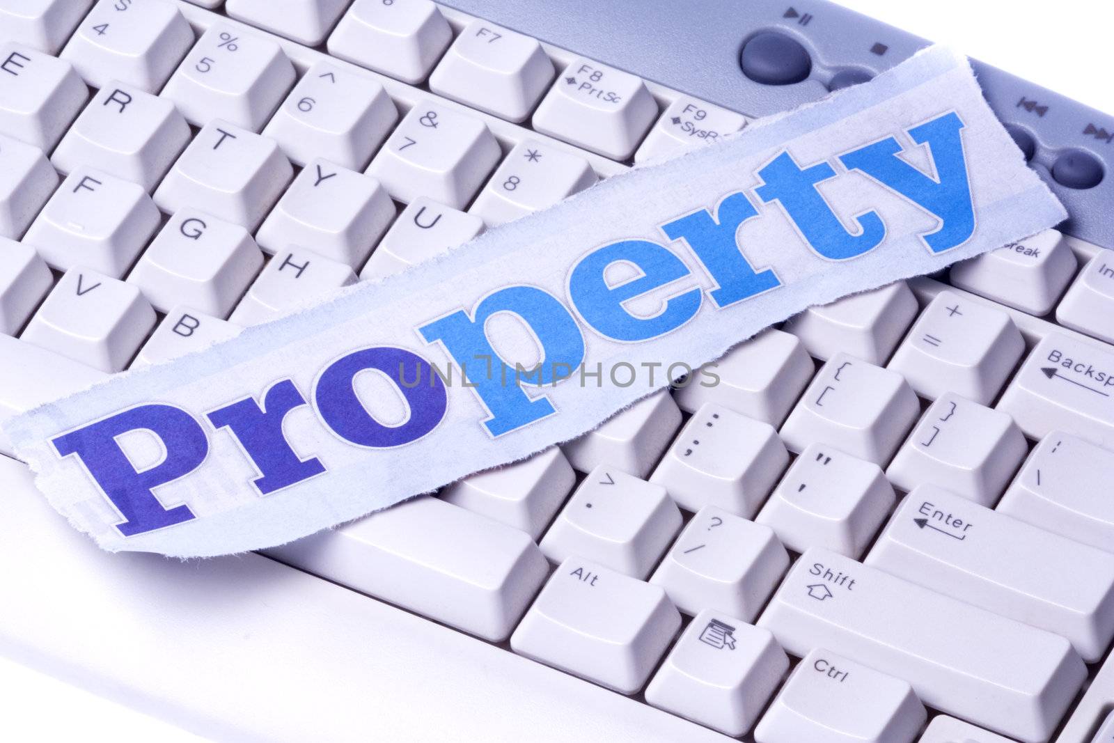 Image of a newspaper cutting with the words "Property" placed on a computer keyboard.