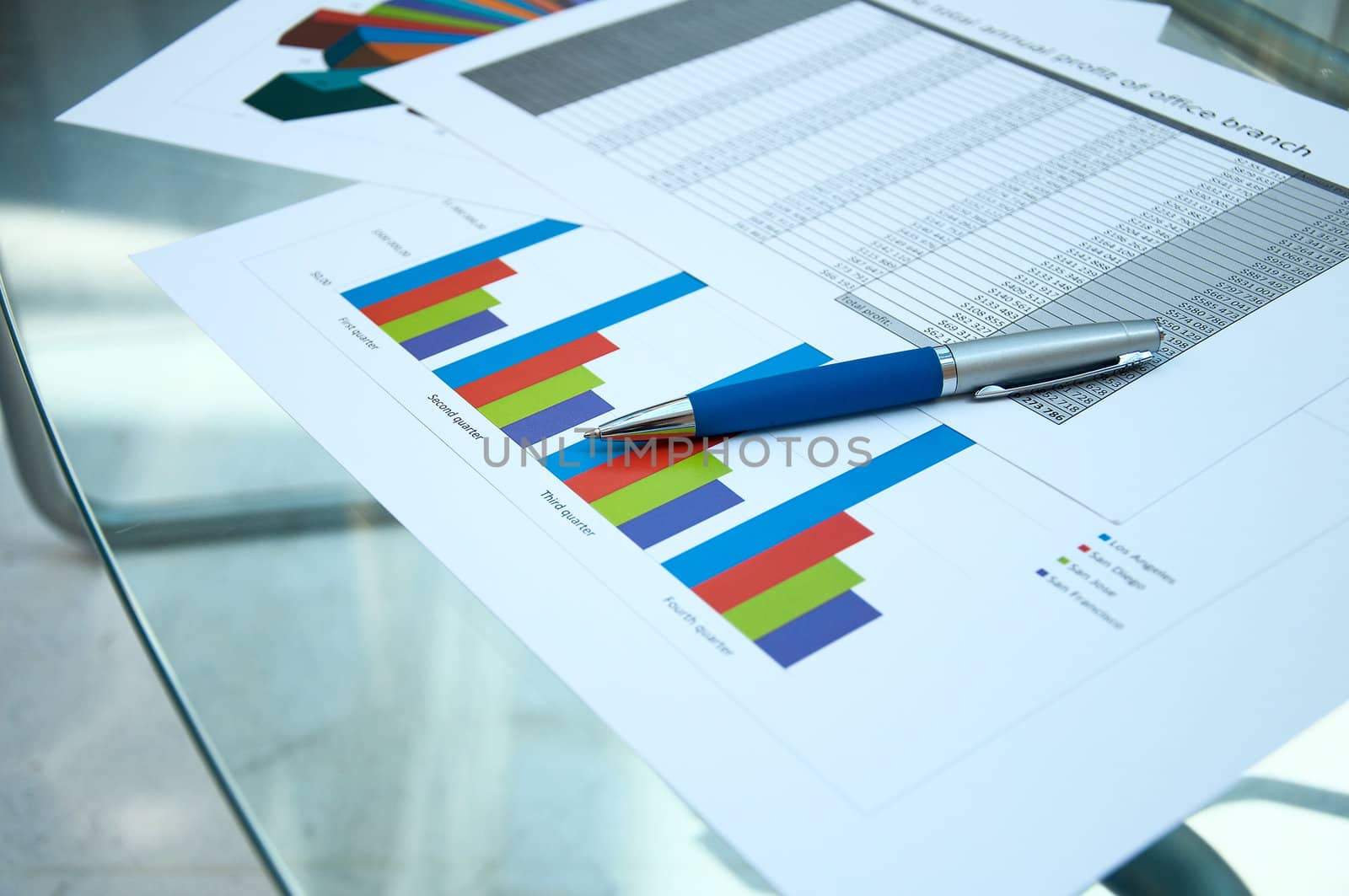 Business documents lay on a glass table at office