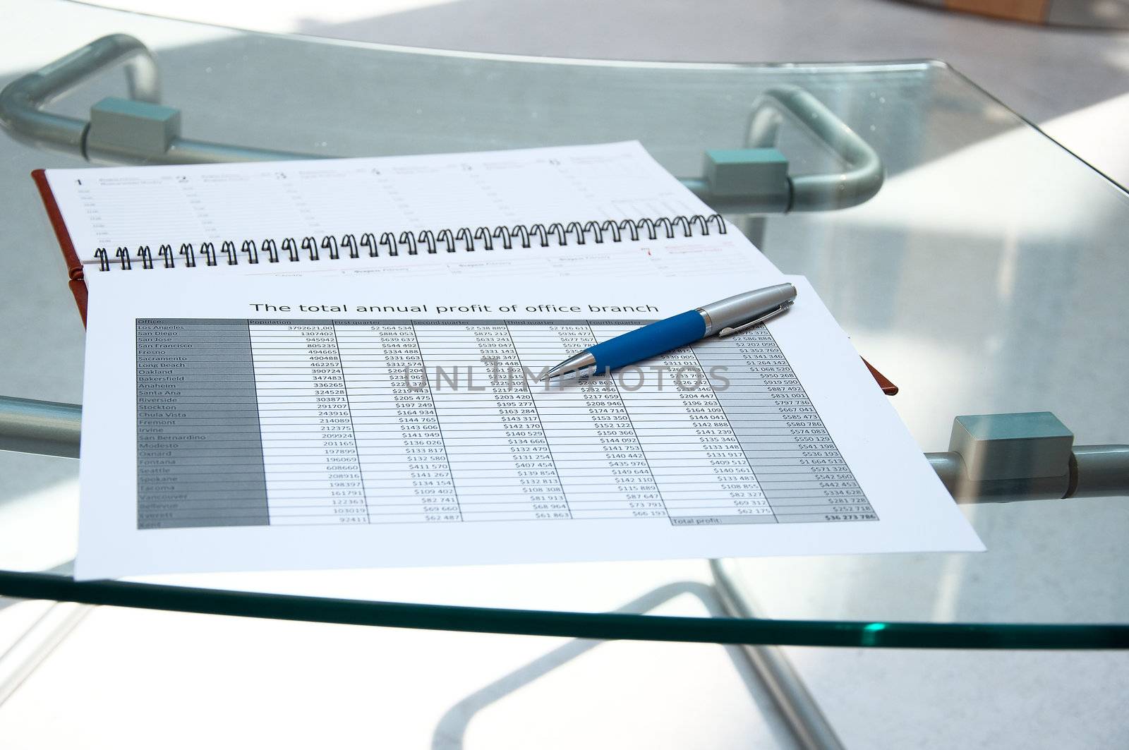 Tables, calendar, pen on a glass table at office