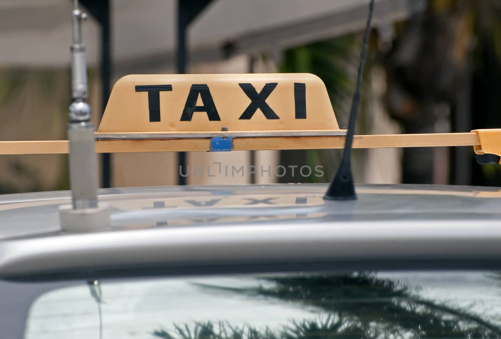 Taxi sign on the roof of an old car.